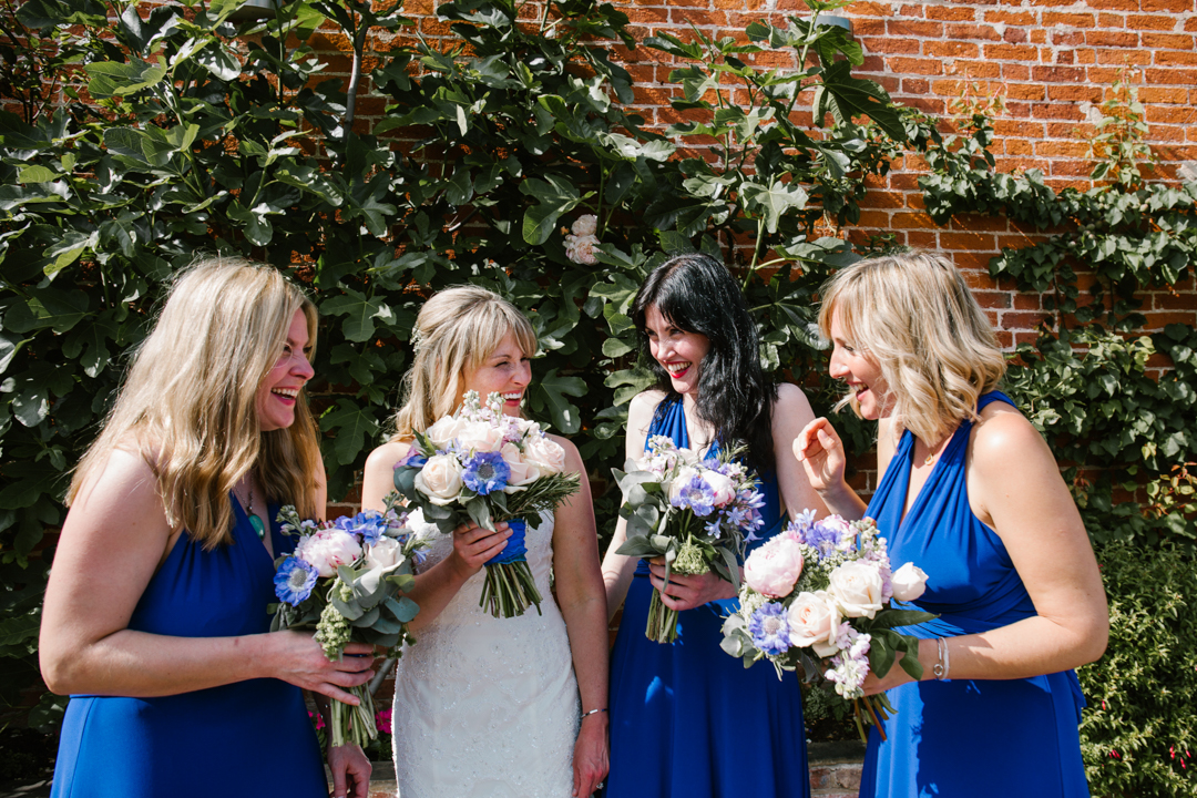 natural fun photo of bridesmaids and bride laughing together at the wedding reception at the walled garden in nottingham