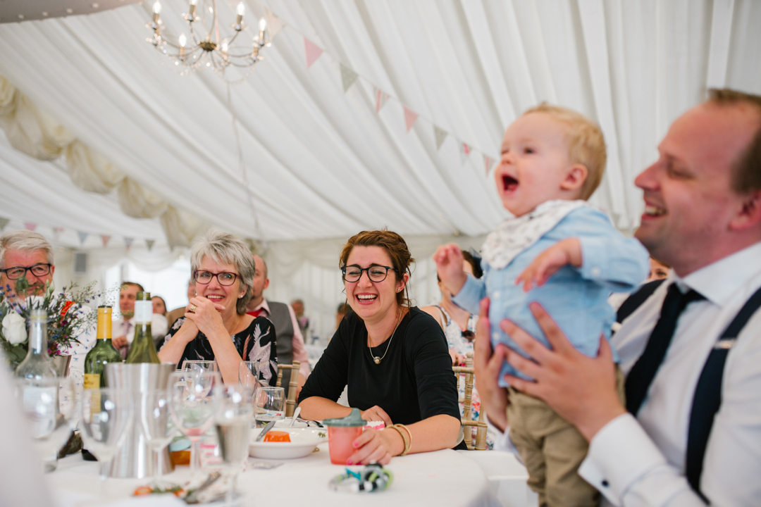 documentary photo of wedding guests and baby laughing during the wedding speeches- nottingham wedding photographer