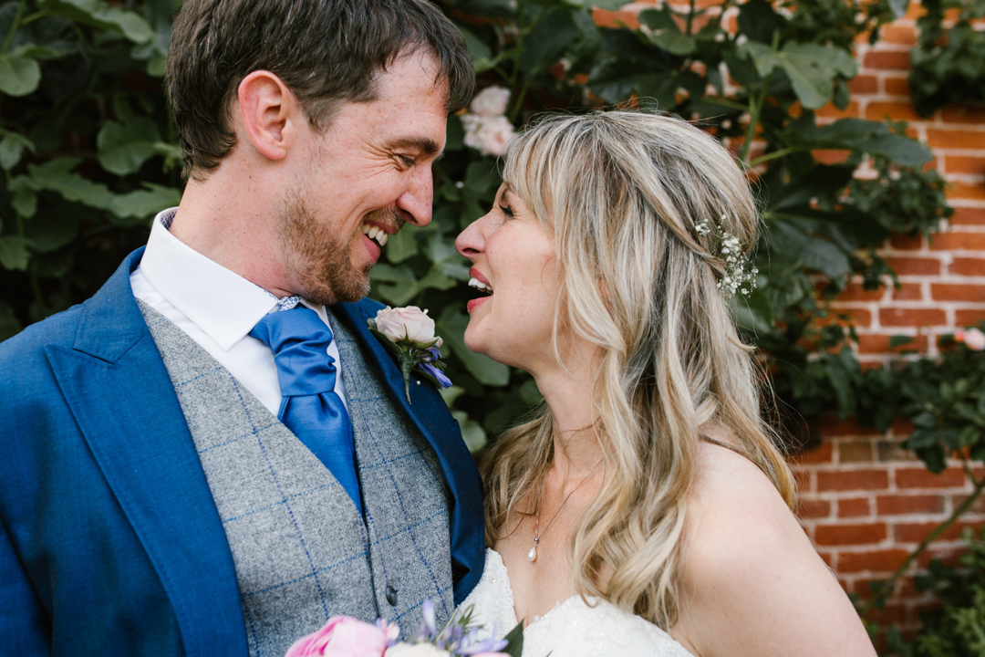 happy photo of bride and groom laughing together at their wedding in the walled garden beeston fields