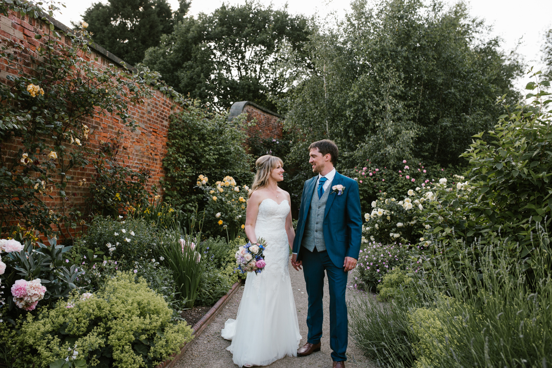 natural and bright photo of bride and groom standing next to one another in the walled garden at beeston fields nottingham