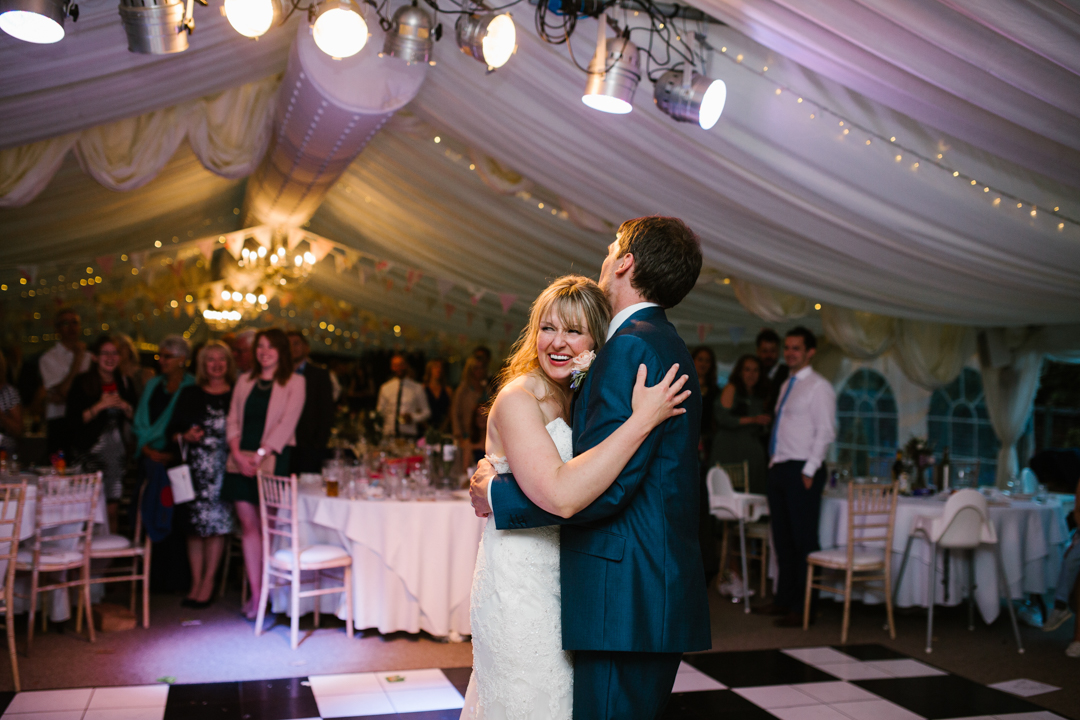 documentary photo of bride and groom hugging on the dance floor during their first dance at the walled garden beeston fields 