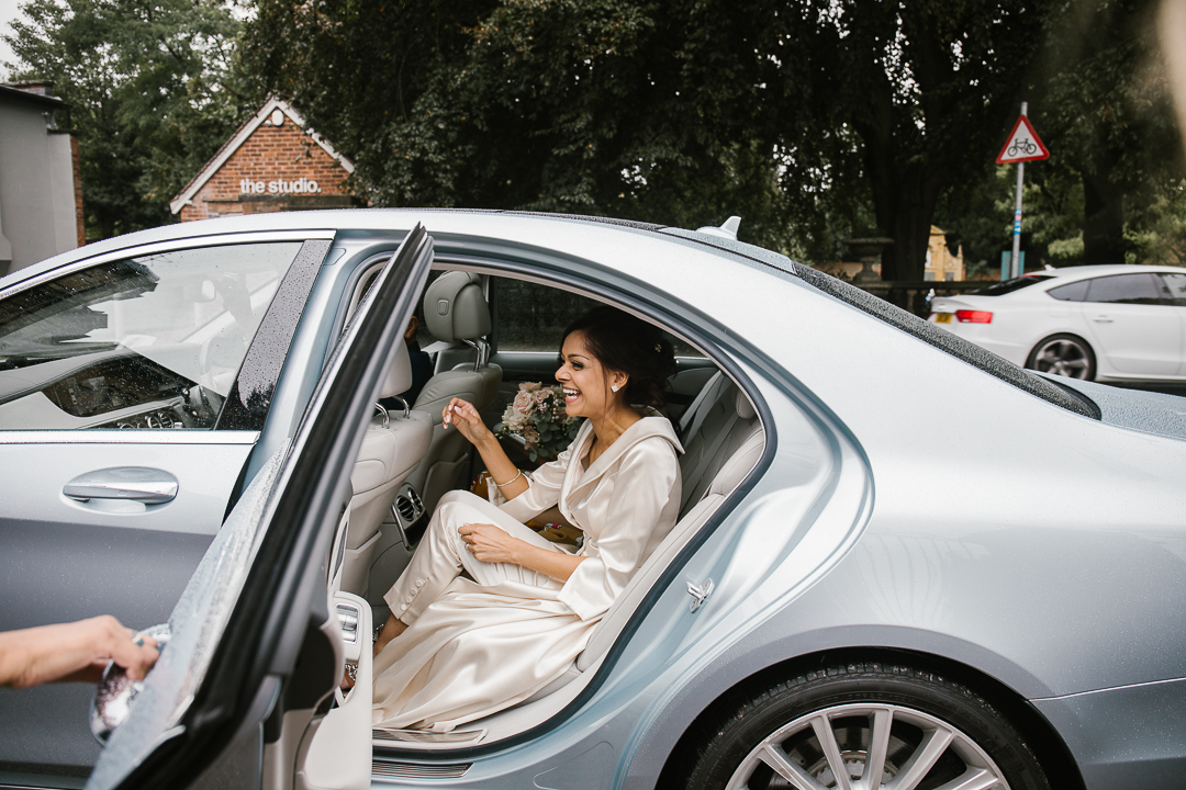 natural candid photo of bride getting out of the mercedes benz on the morning of her wedding
