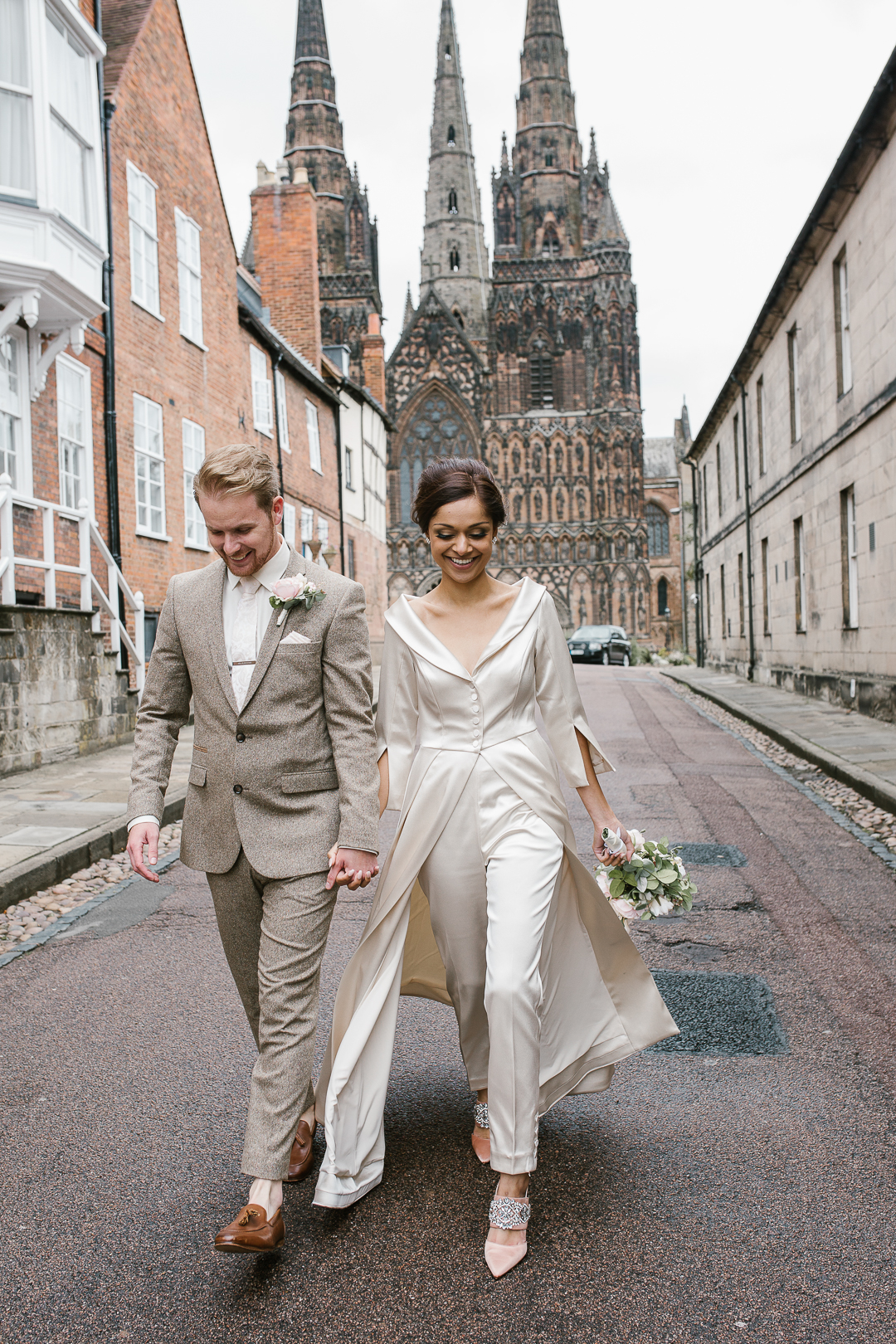 happy fun photo of bride and groom laughing infront of lichfield cathedral- natural wedding photographer in staffordshire