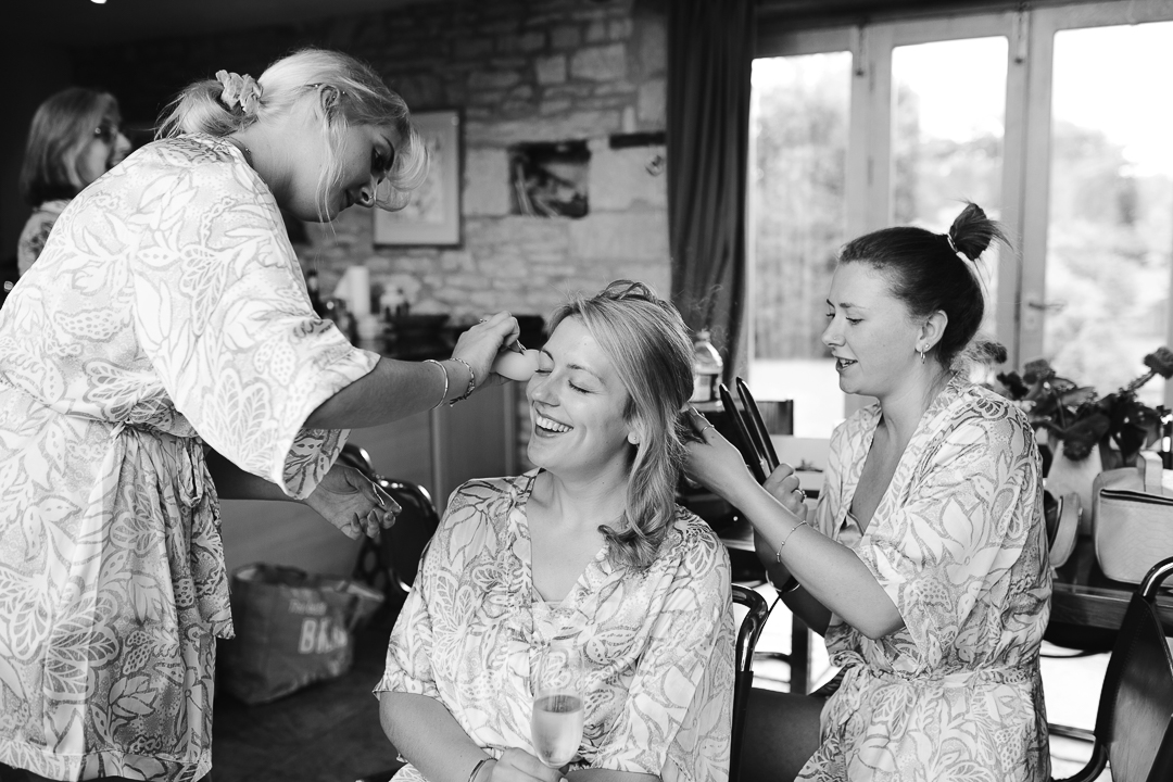 black and white natural photo of bride having hair and make up done on the morning of her wedding