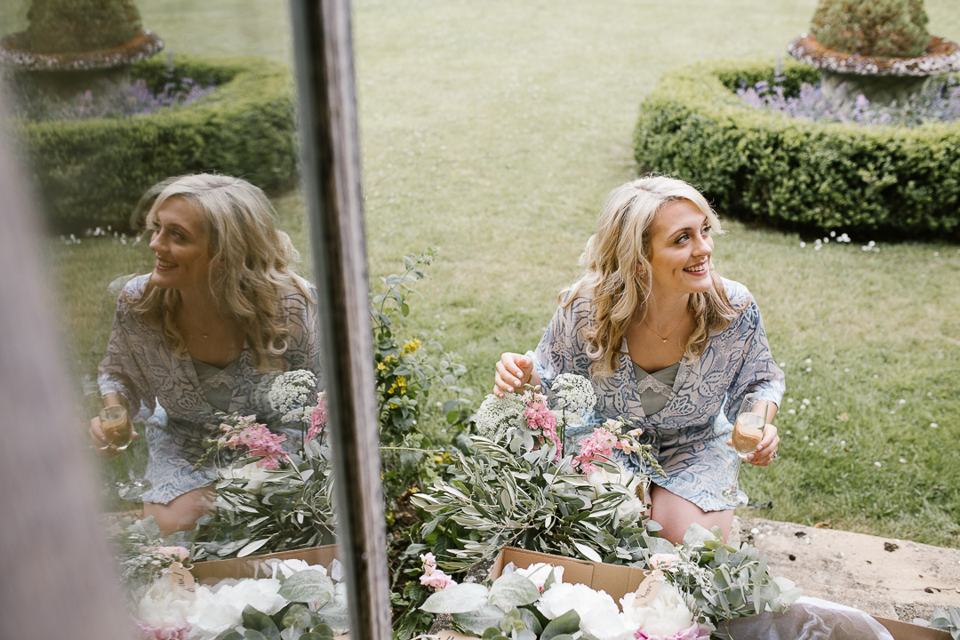 natural photo of bride smiling as her beautiful wild flowers get delivered for her wedding
