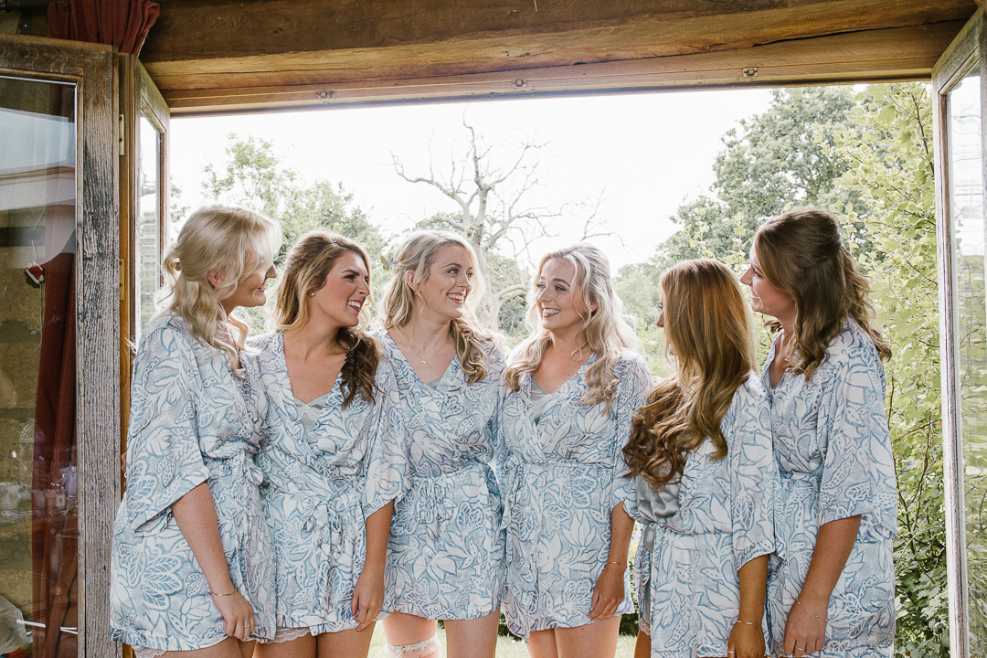 natural fun photo of bride with her bridesmaids on the morning of her wedding in matching robes