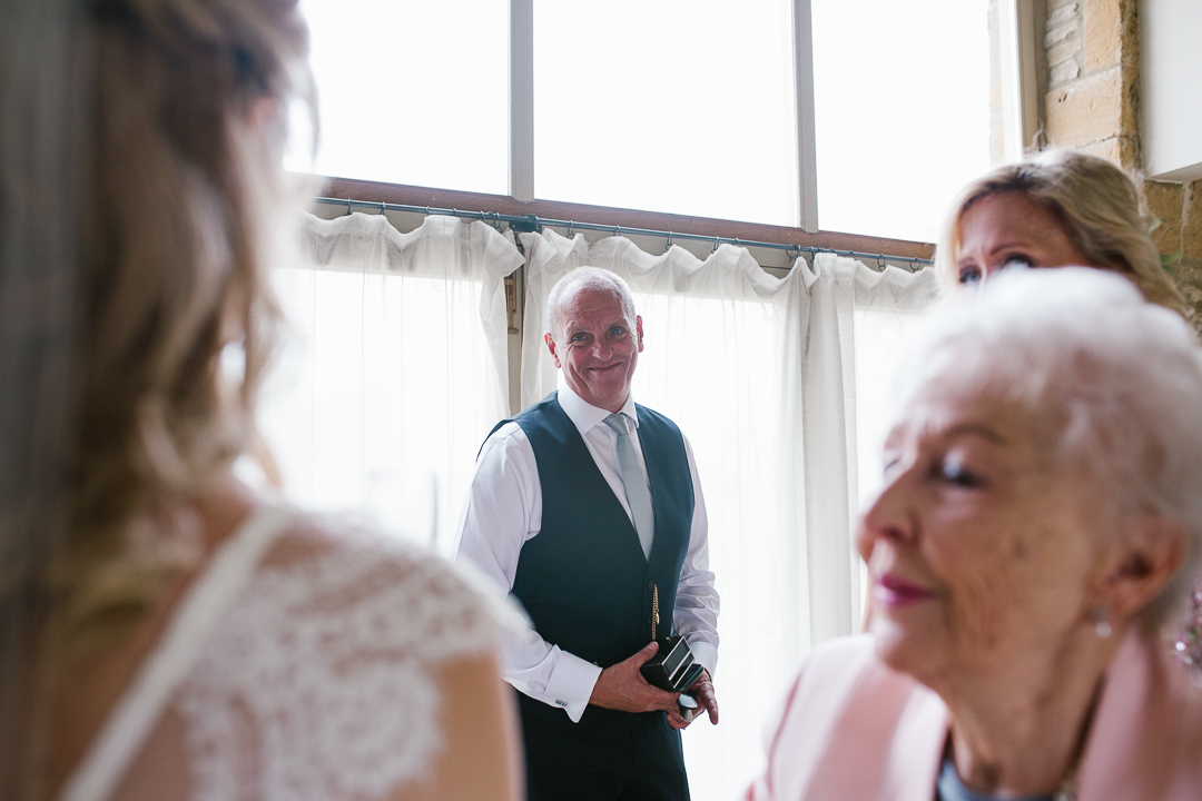 emotional and happy photo of father of the bride as he sees his daughter in her wedding dress for the first time