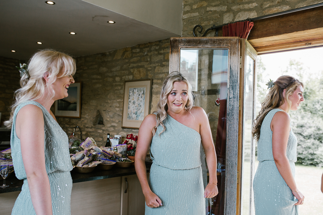 candid photo of bridesmaid crying after she sees the bride in her dress for the first time- cotswolds wedding