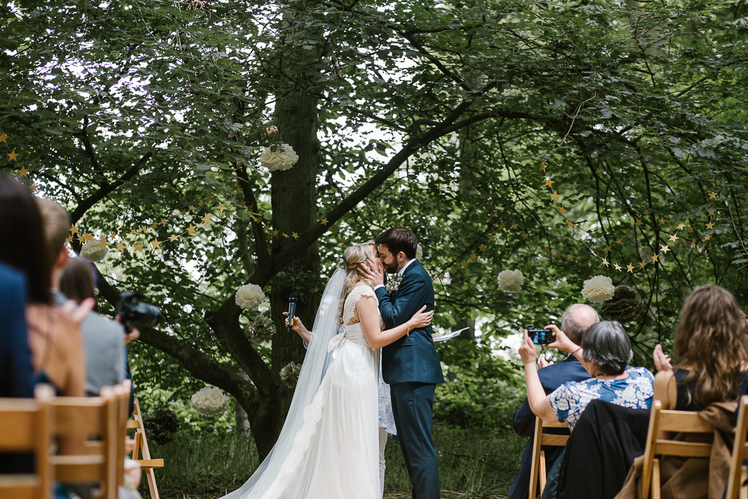 happy photo of the bride and groom having their first kiss