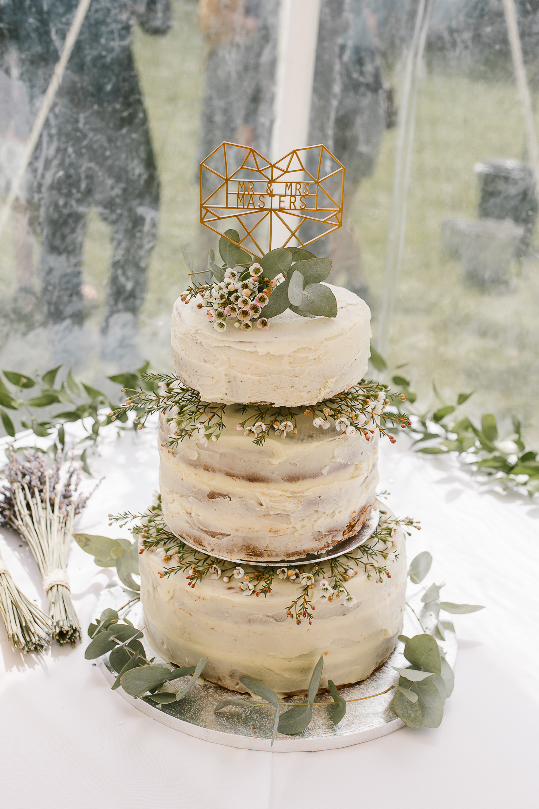 three tiered naked cake at marquee wedding in the cotswolds