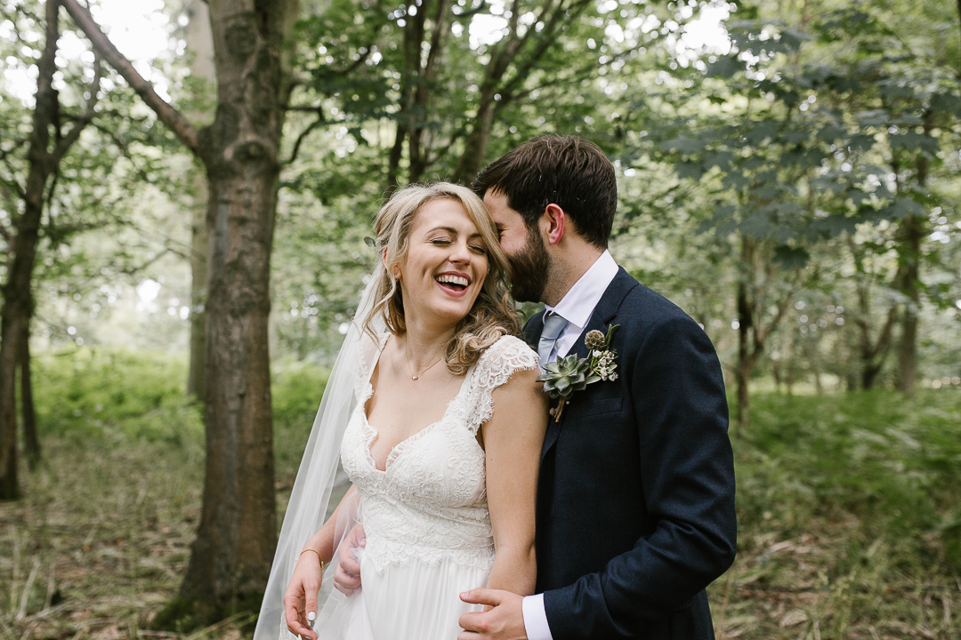 fun photo of bride and groom laughing together at their summer wedding 