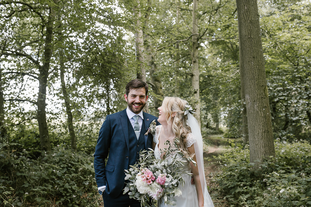 happy photo of bride and groom in the woodlands  at their woodland wedding in the cotswolds