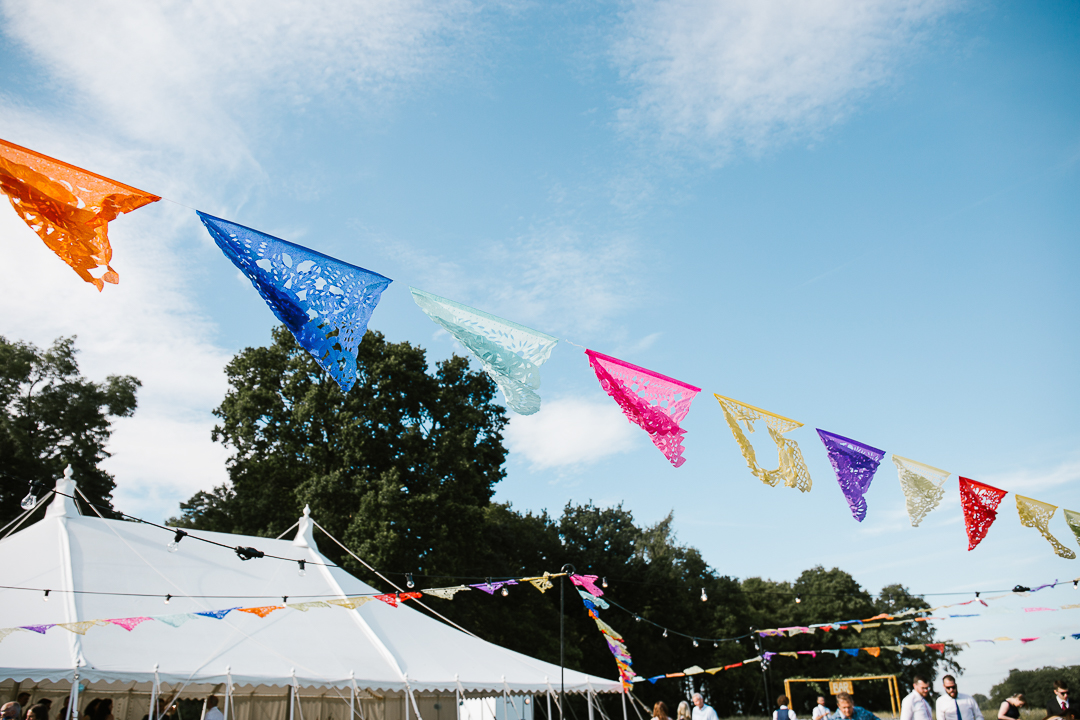 Mexican style bunting hanging at marquee wedding