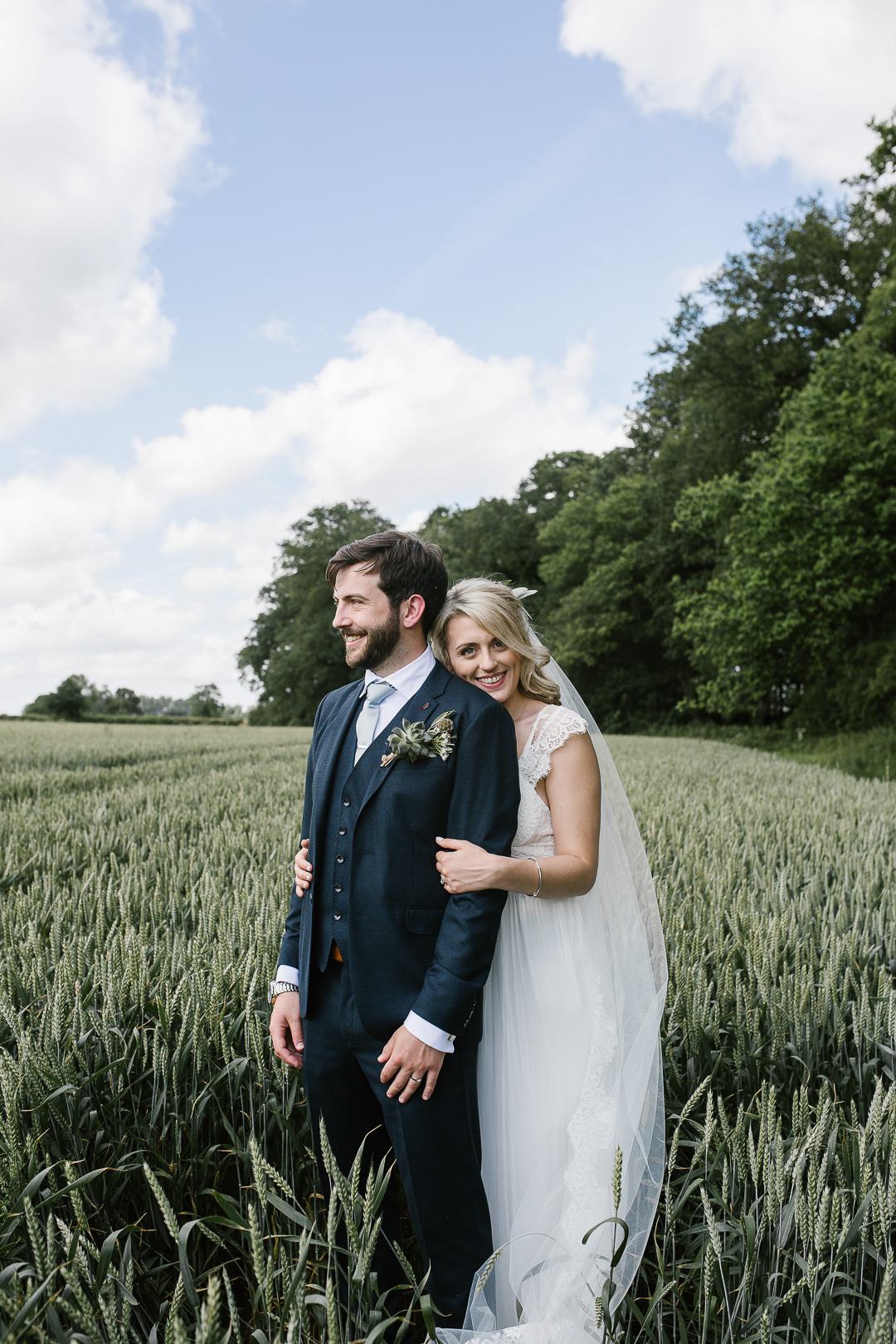 natural photo of bride and groom standing in a field at outdoor ceremony in the cotswolds