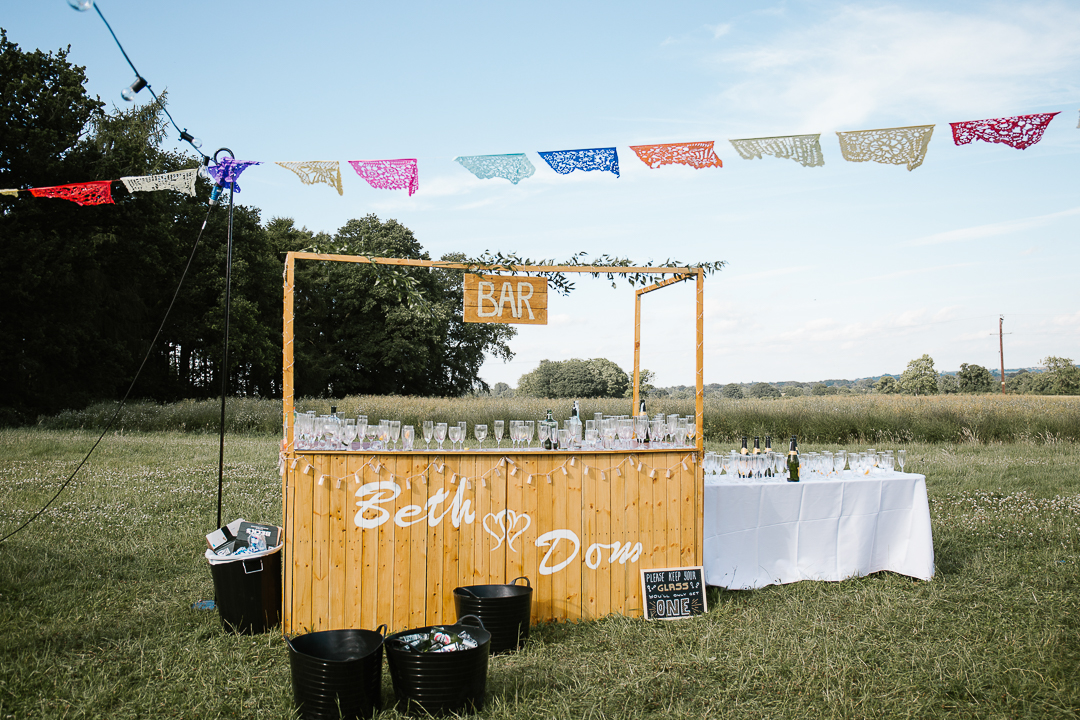 diy made wooden bar at outdoor festival themed cotswolds wedding