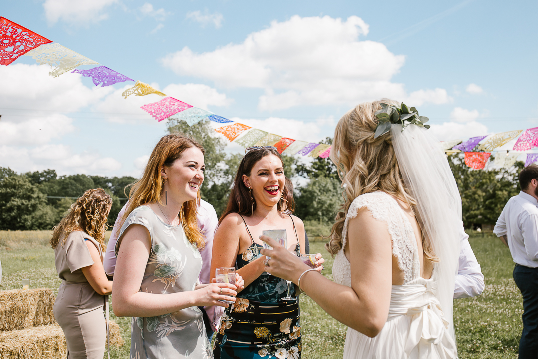 candid photo of summer wedding of guests laughing 