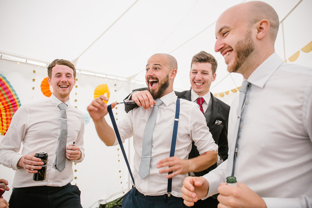 fun photo of groomsmen dancing at the festival themed wedding