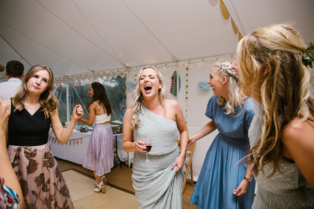 candid photo of bridesmaids laughing on the dance floor at the marquee wedding venue