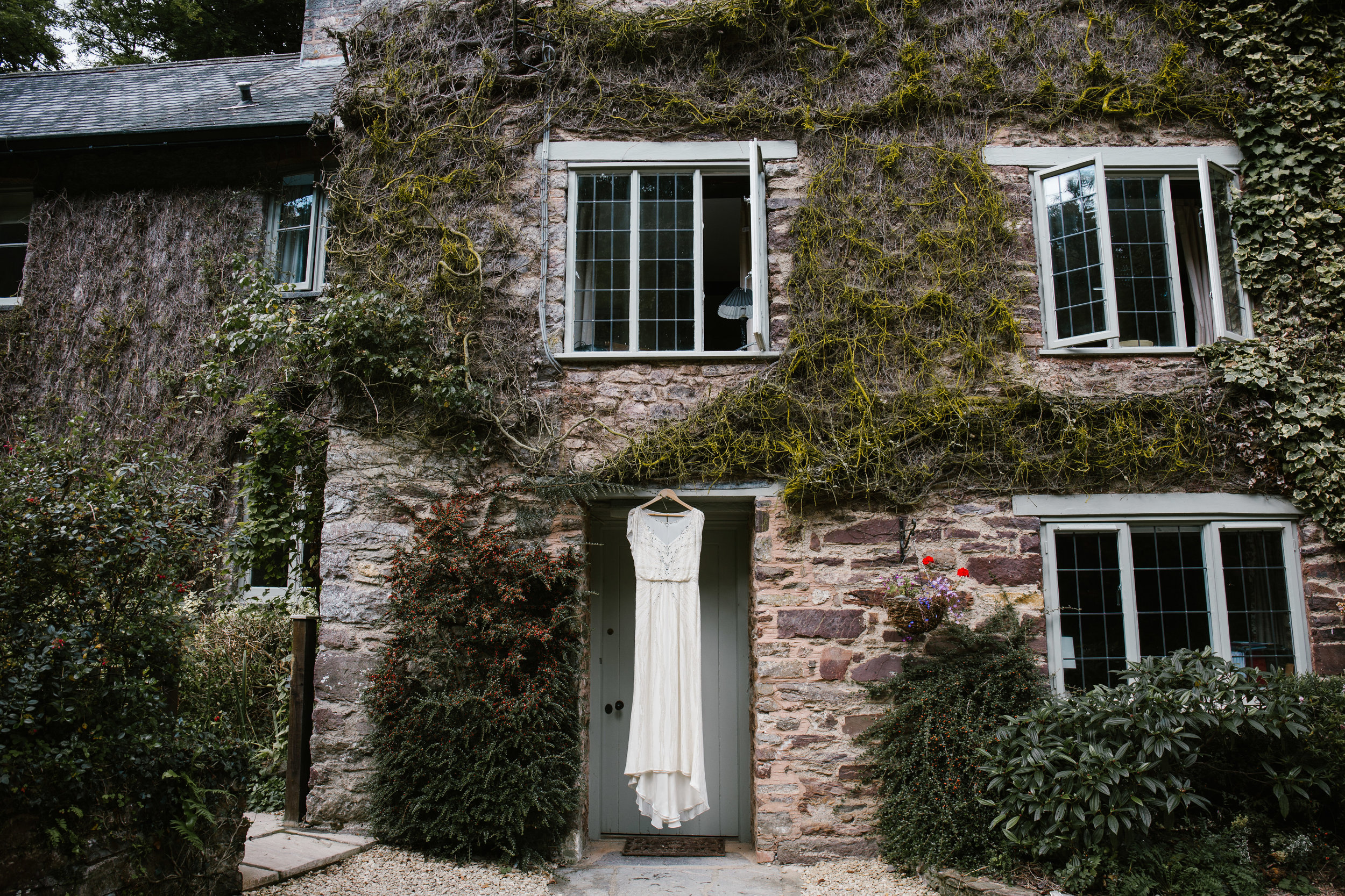 jenny packham dress hanging on a ivy covered cottage