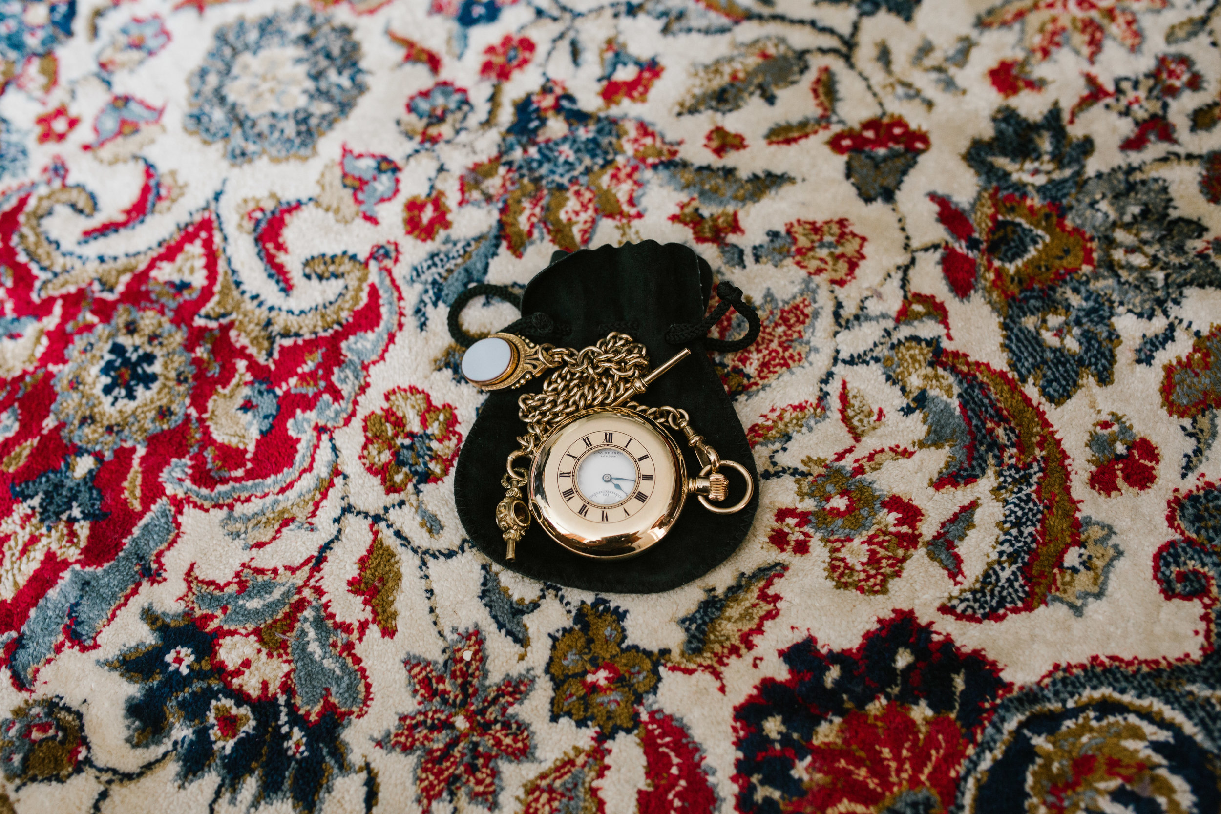 antique pocket watch on patterned carpet