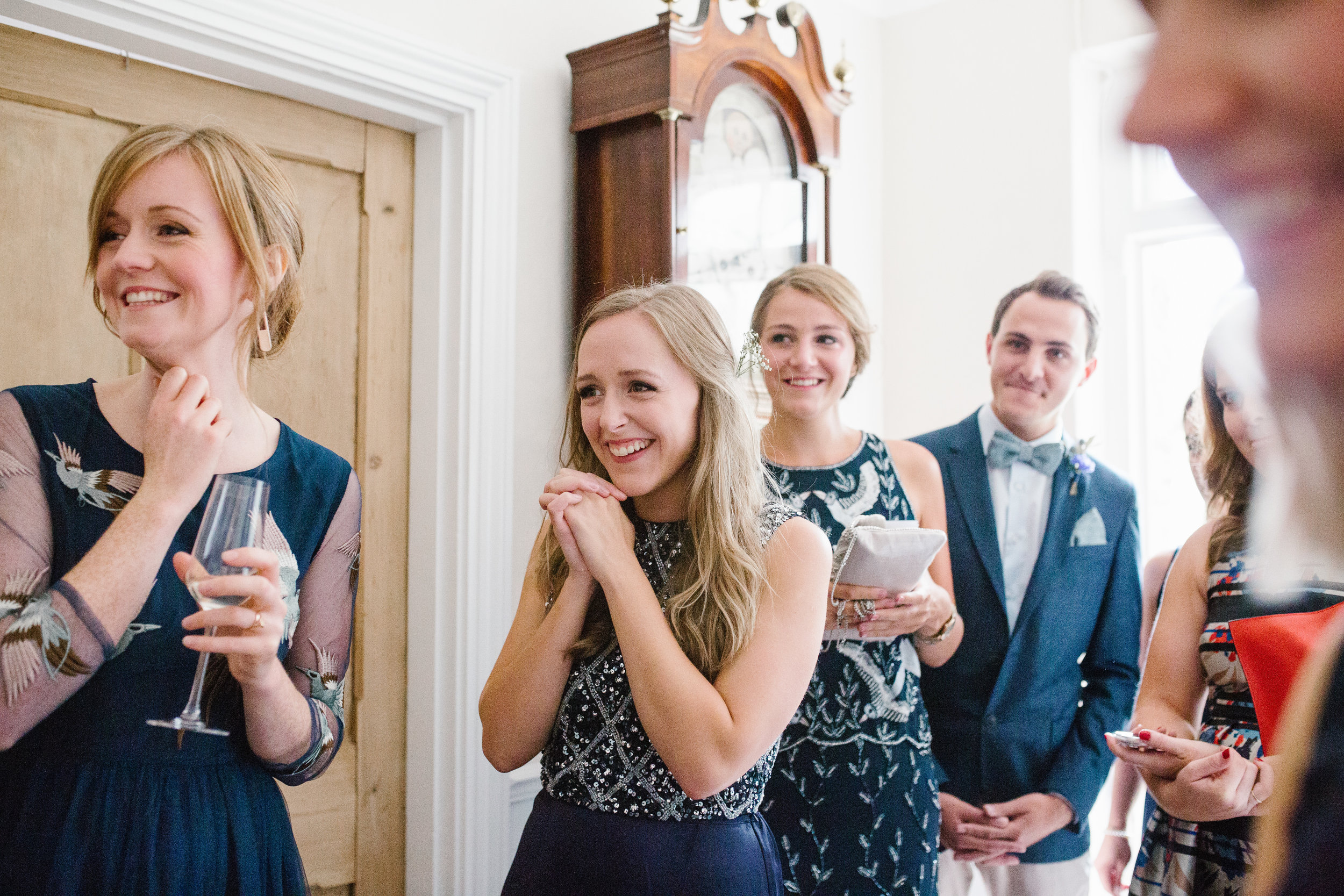 bridesmaids smiling as they see the bride for the first time