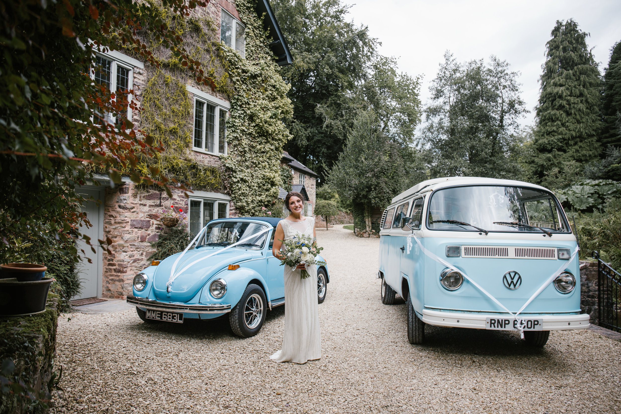 blue vw campervan and vw beetle as wedding cars for the outdoor wedding ceremony 