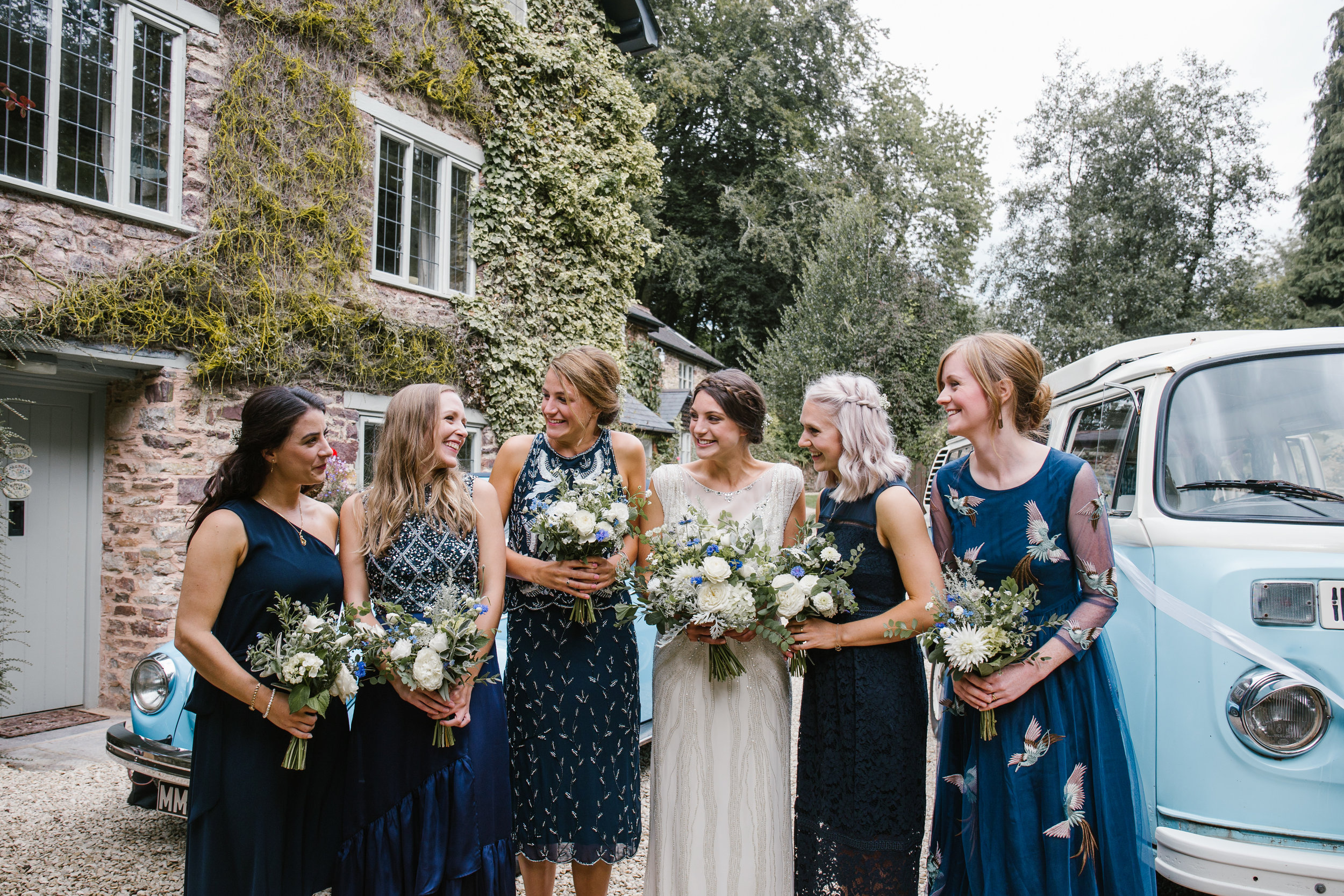 natural photo of bride and bridesmaids laughing together before the outdoor wedding ceremony