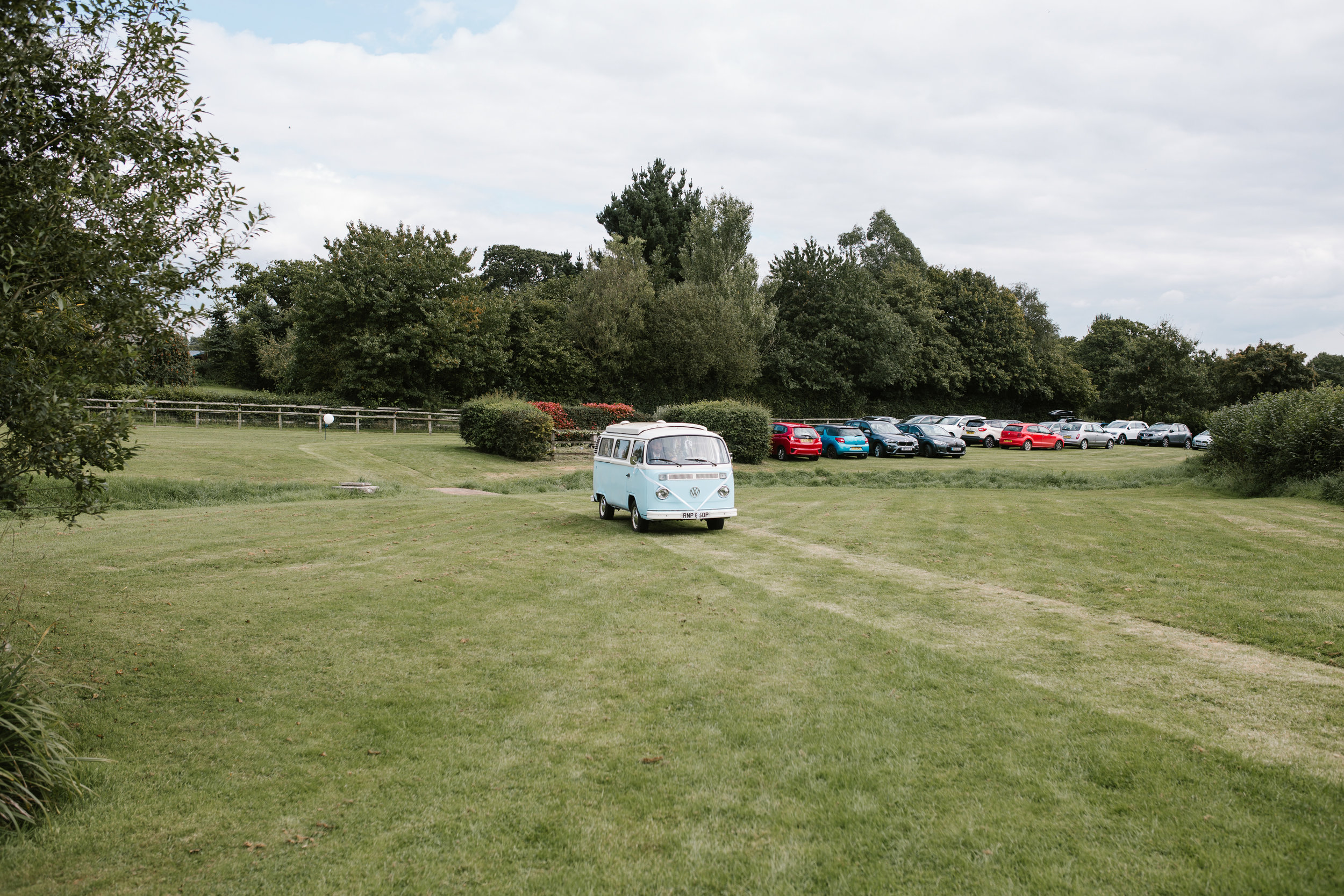 light vw campervan arriving at back garden wedding ceremony