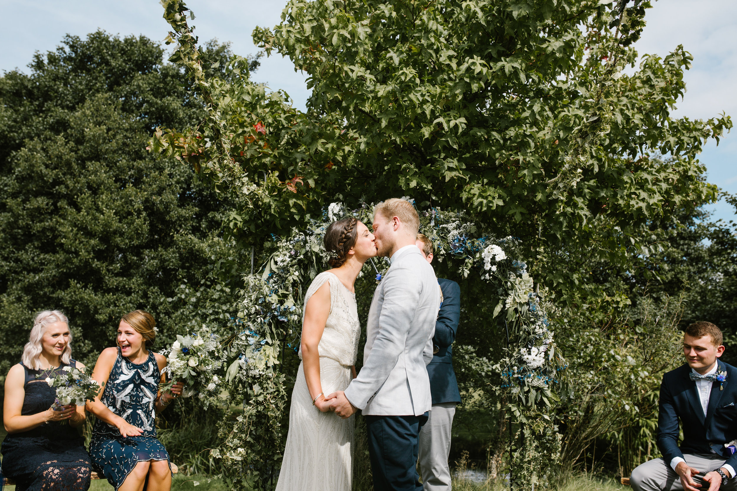 bride and groom kissing at their outdoor wedding ceremony