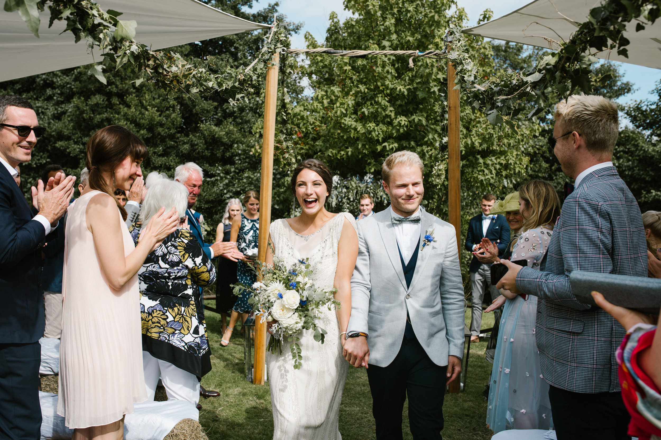 boho bride and groom walking down the aisle after their outdoor back garden ceremony