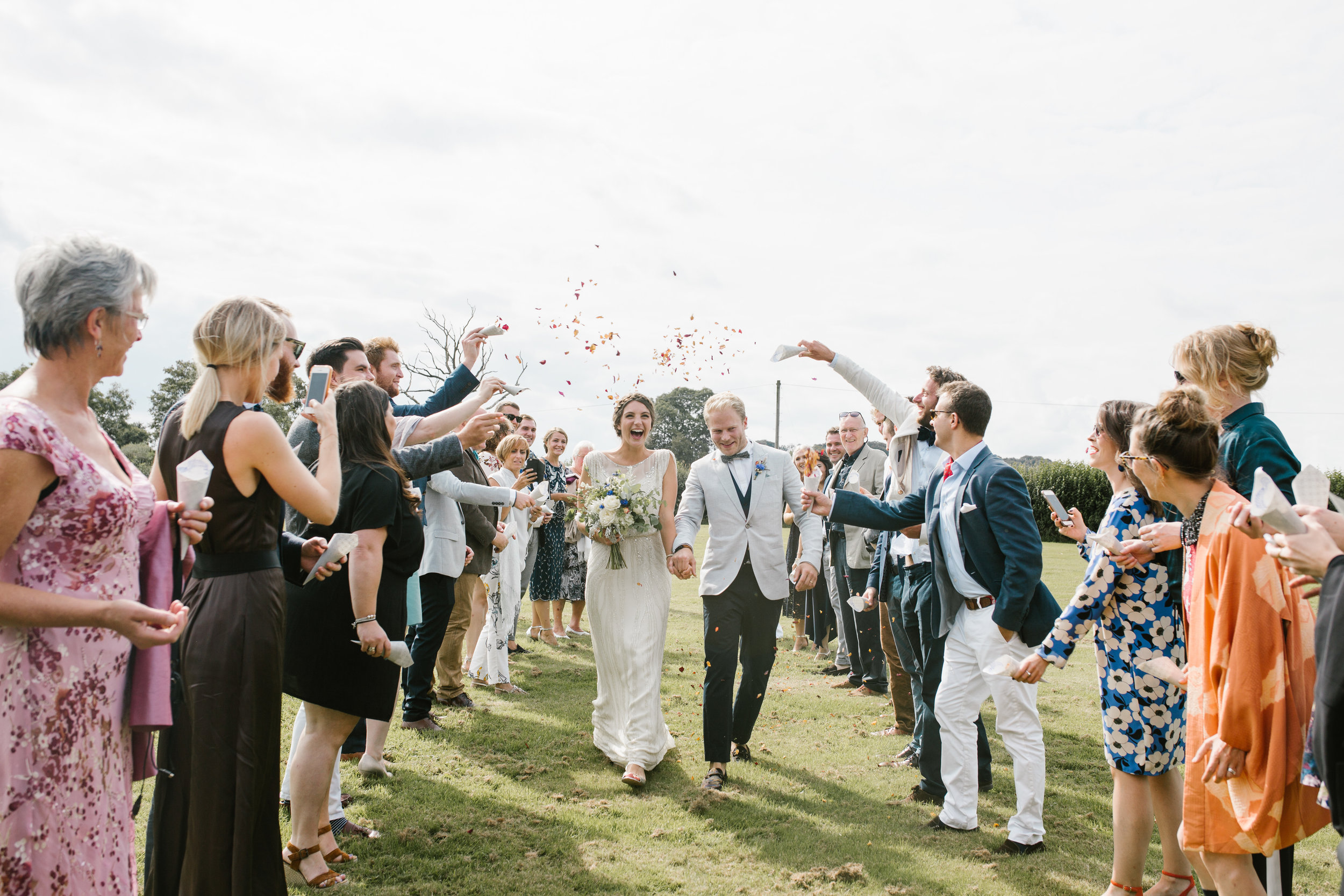 newlyweds after their back garden wedding being showered in confetti