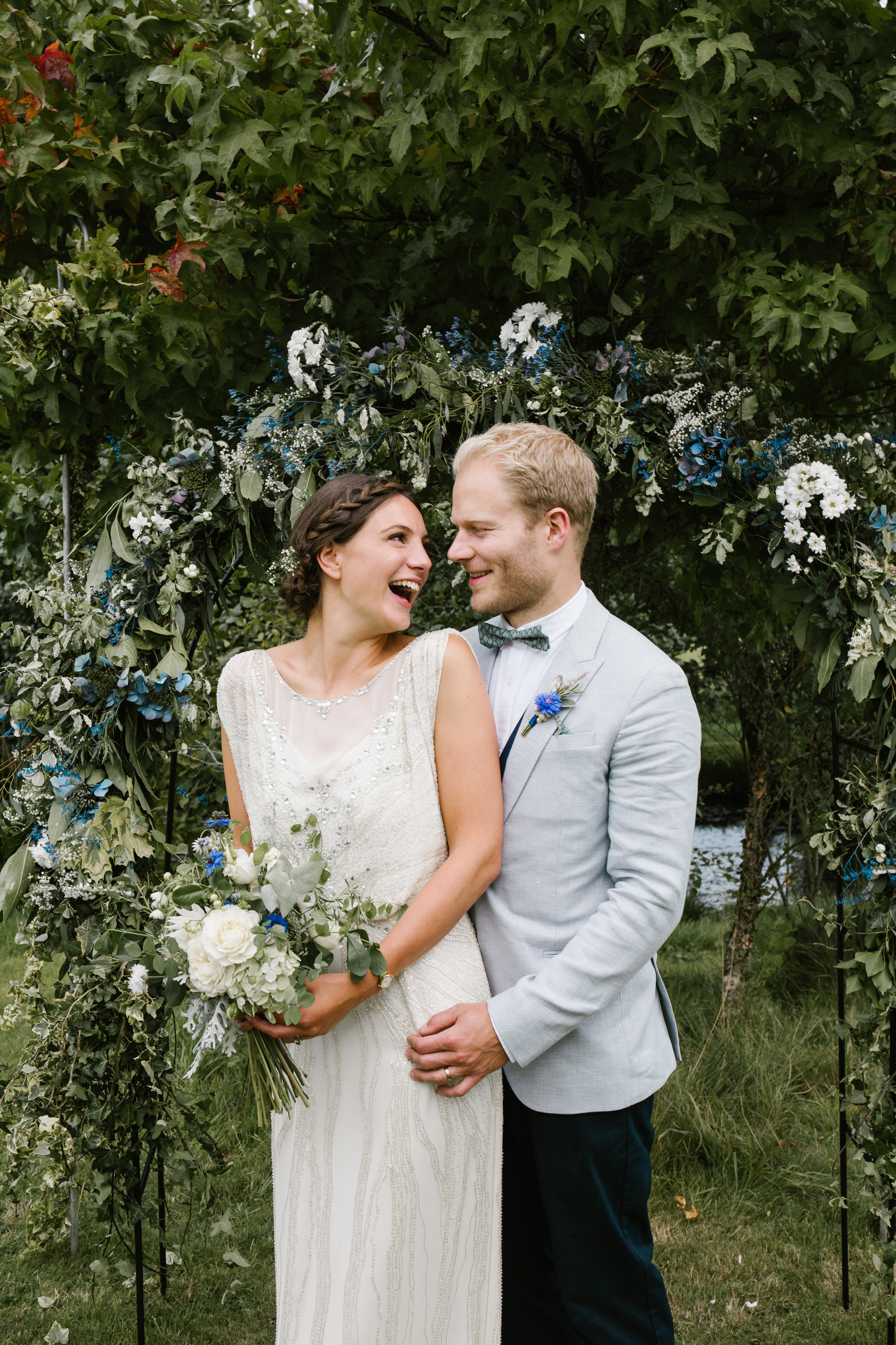 natural photo of bride and groom laughing tiether after their outdoor wedding ceremony 