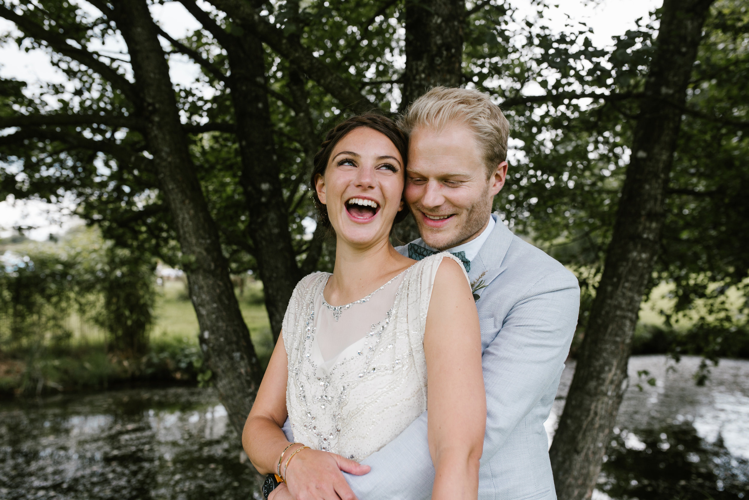 happy fun photo of bride and groom holiding each other close and laughing together 