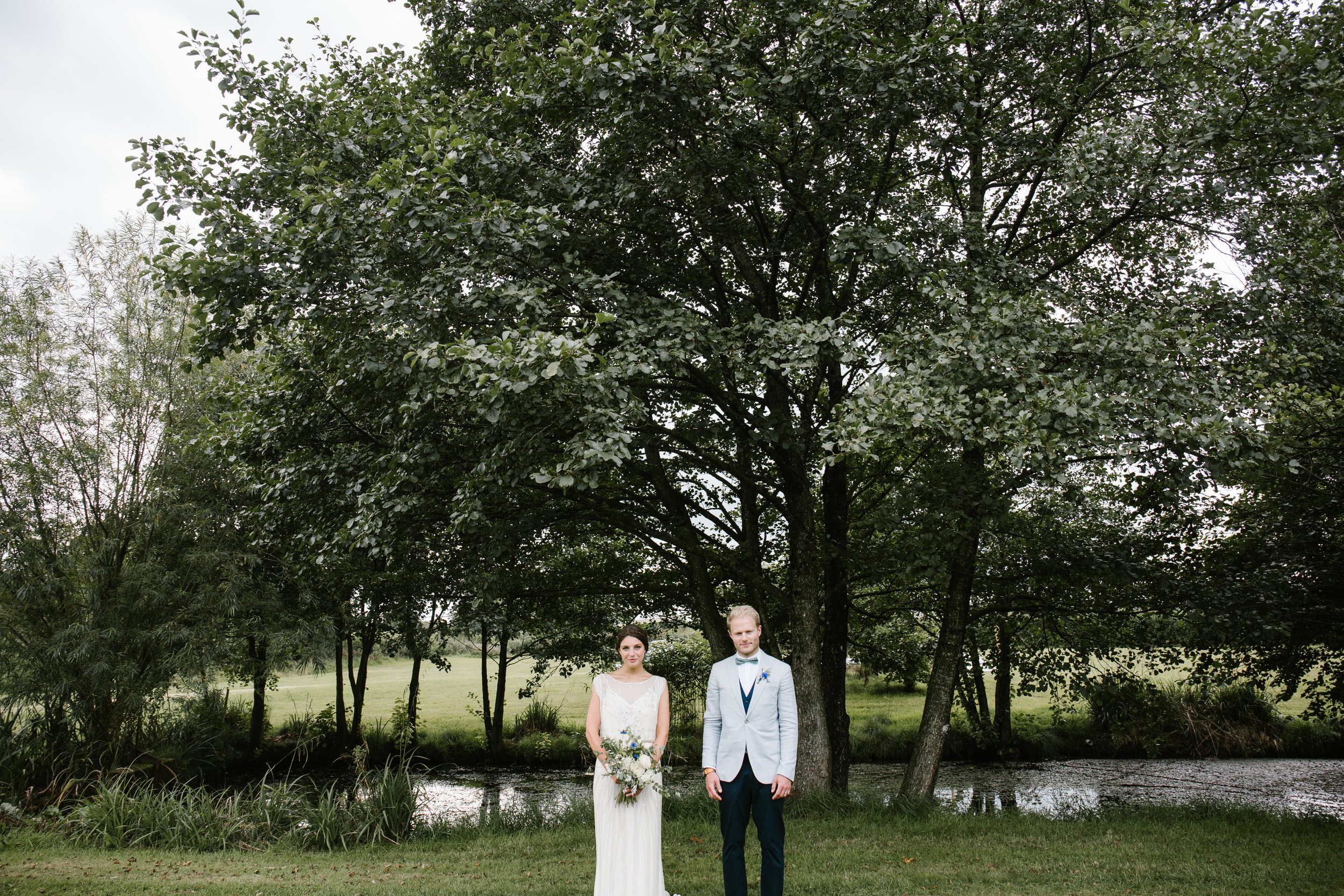 quirky photo of bride and groom stood together in the back garden of where they got married