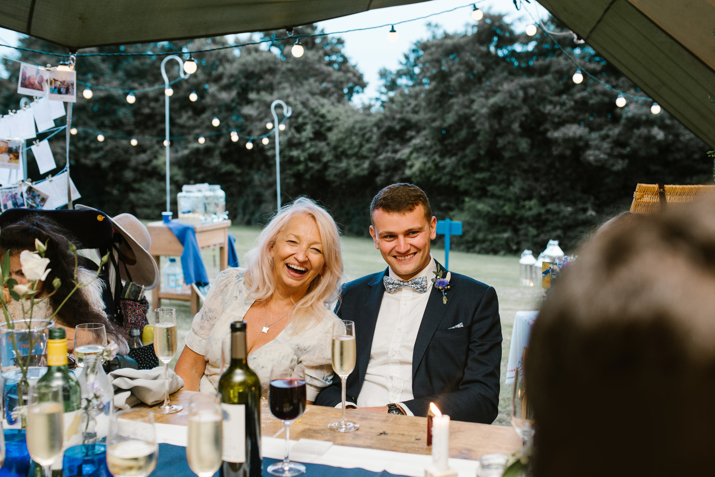 wedding guests laughing together as they laugh at speeches