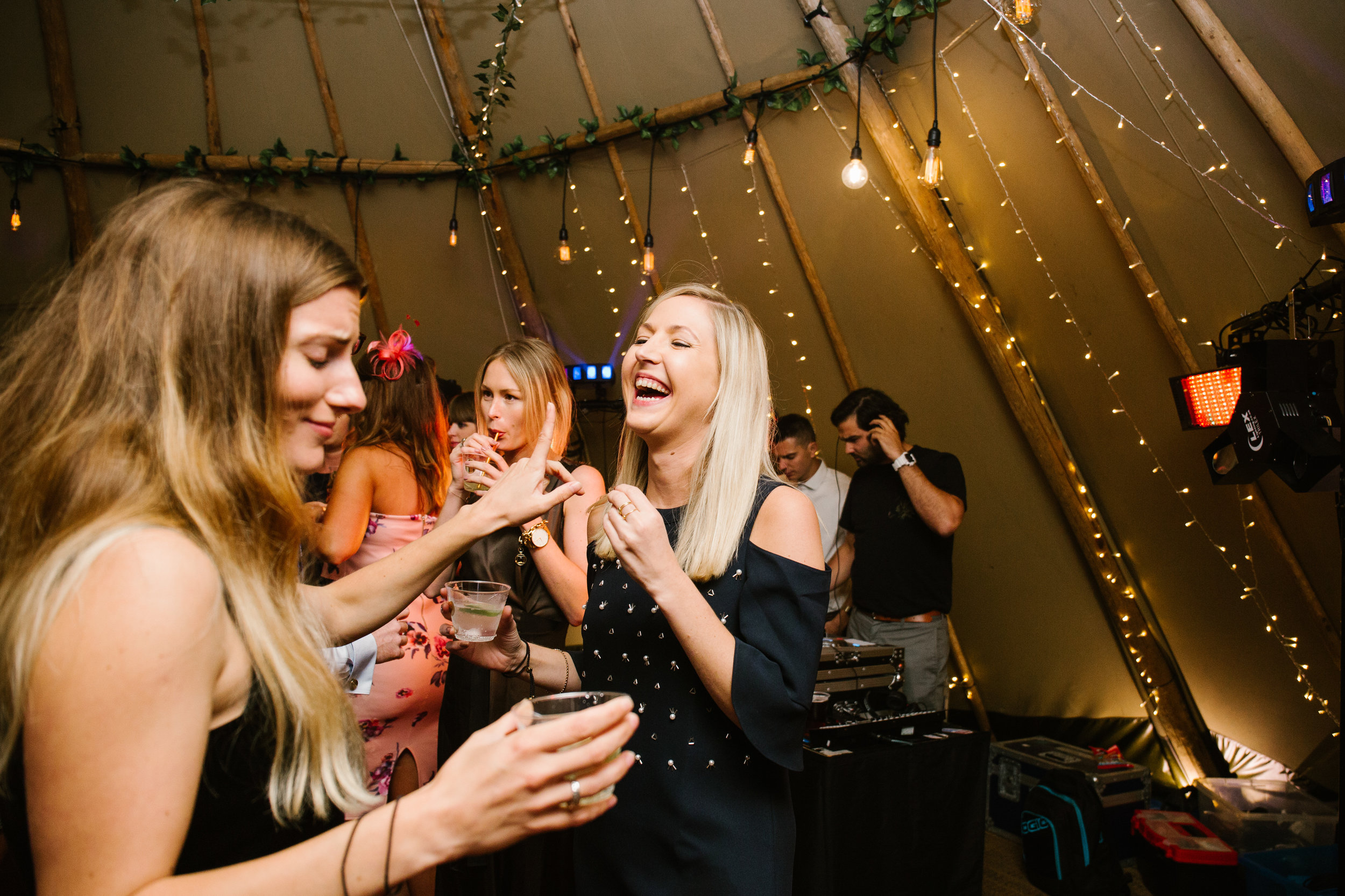 natural photo of wedding guests laughing on the dance floor at a tipi wedding 