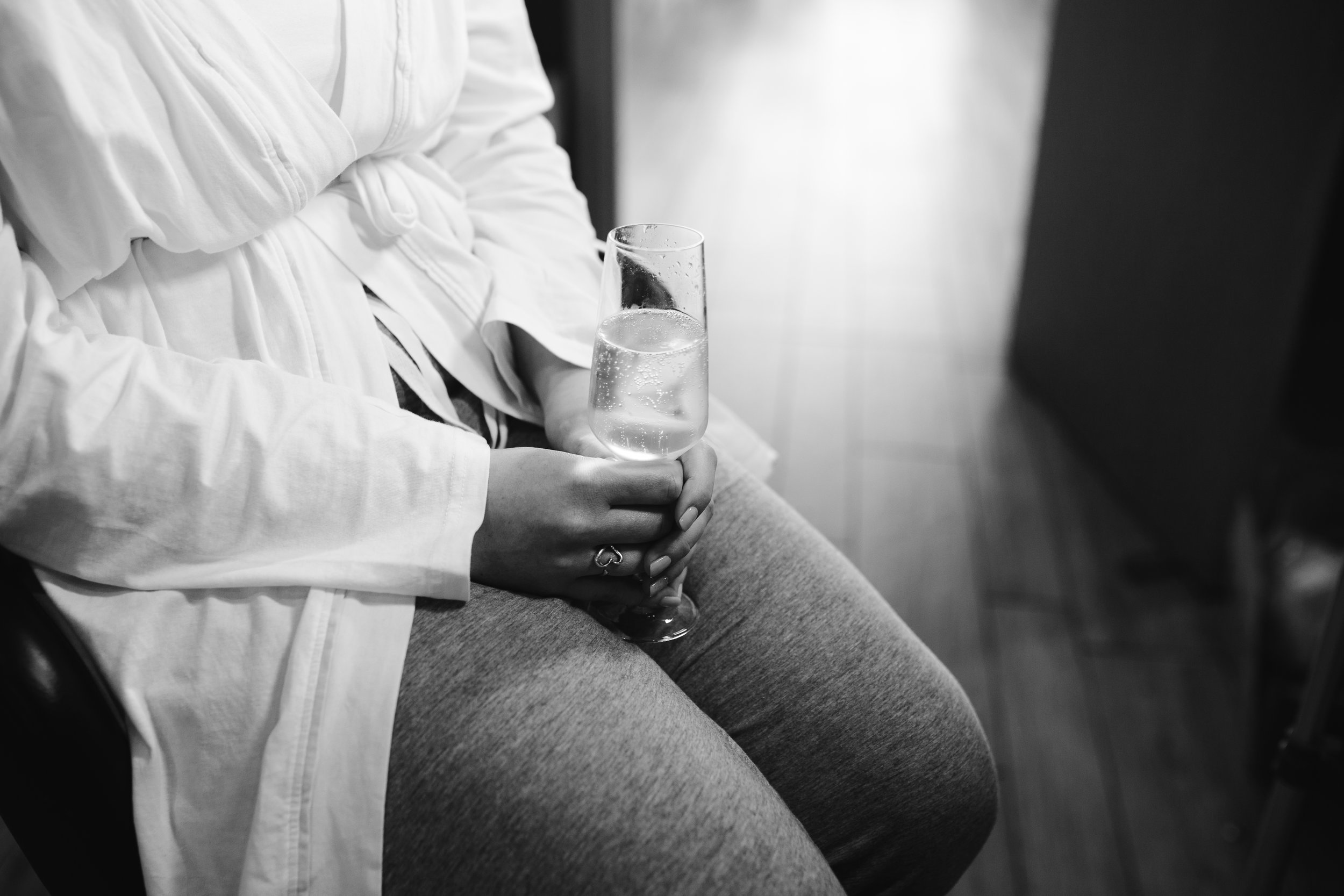 black and white photo of bride holding prosecco 