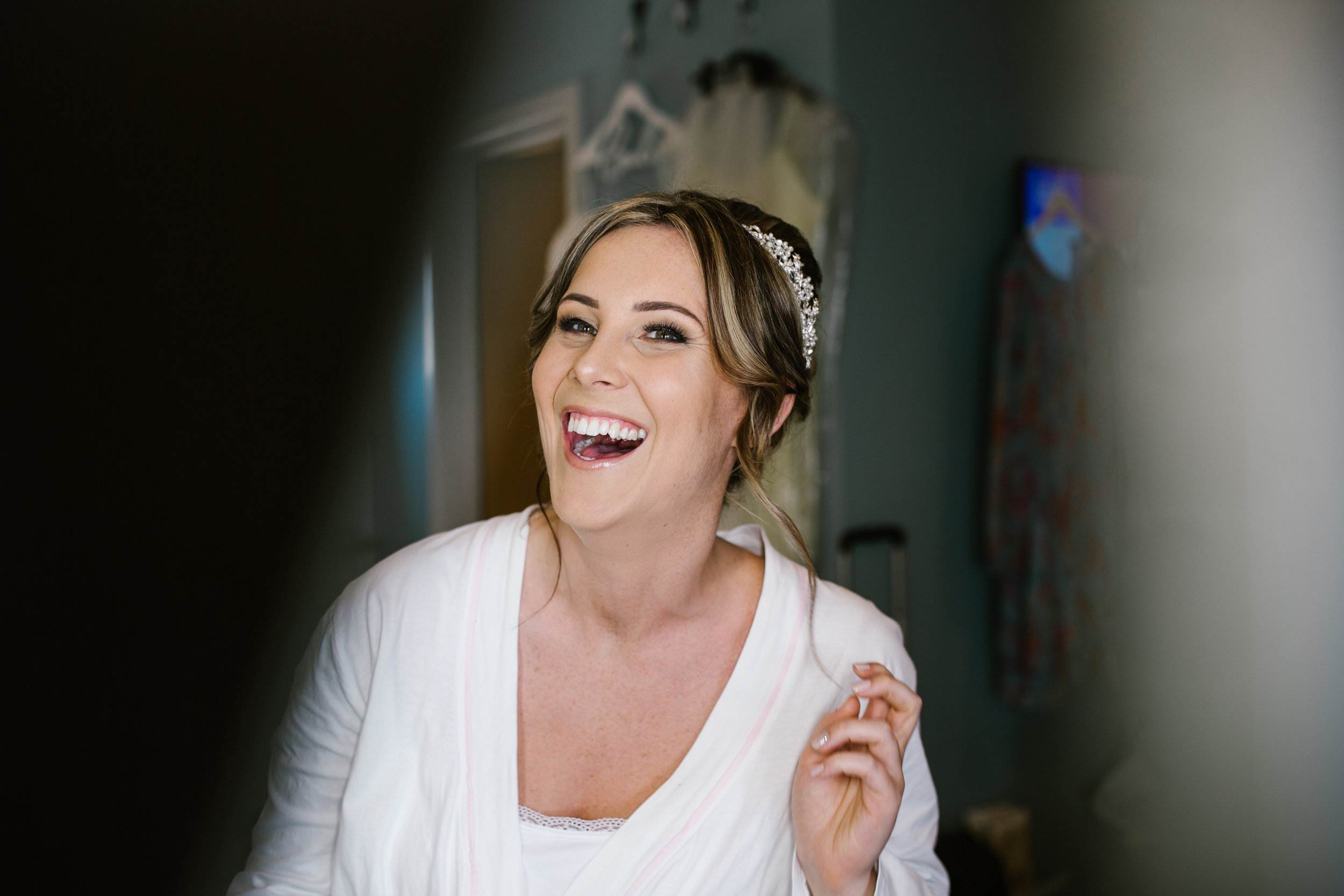 Natural photograph of bride laughing during her bridal preparation 