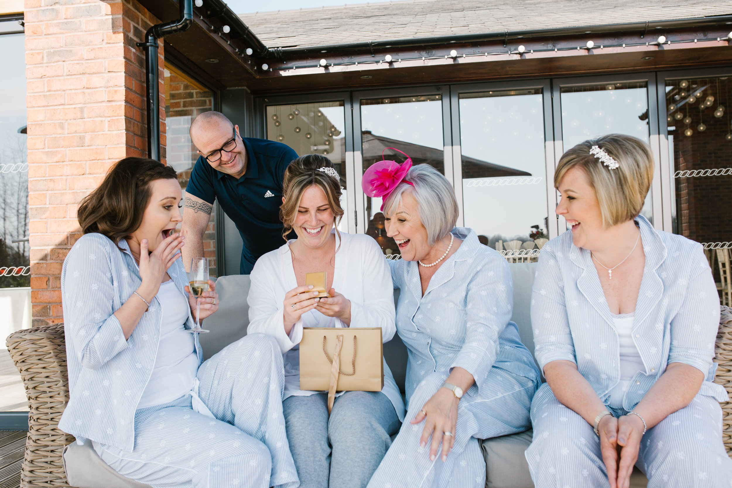 bride with her family opening presents off her groom on the morning off the wedding at the boat house aston marina