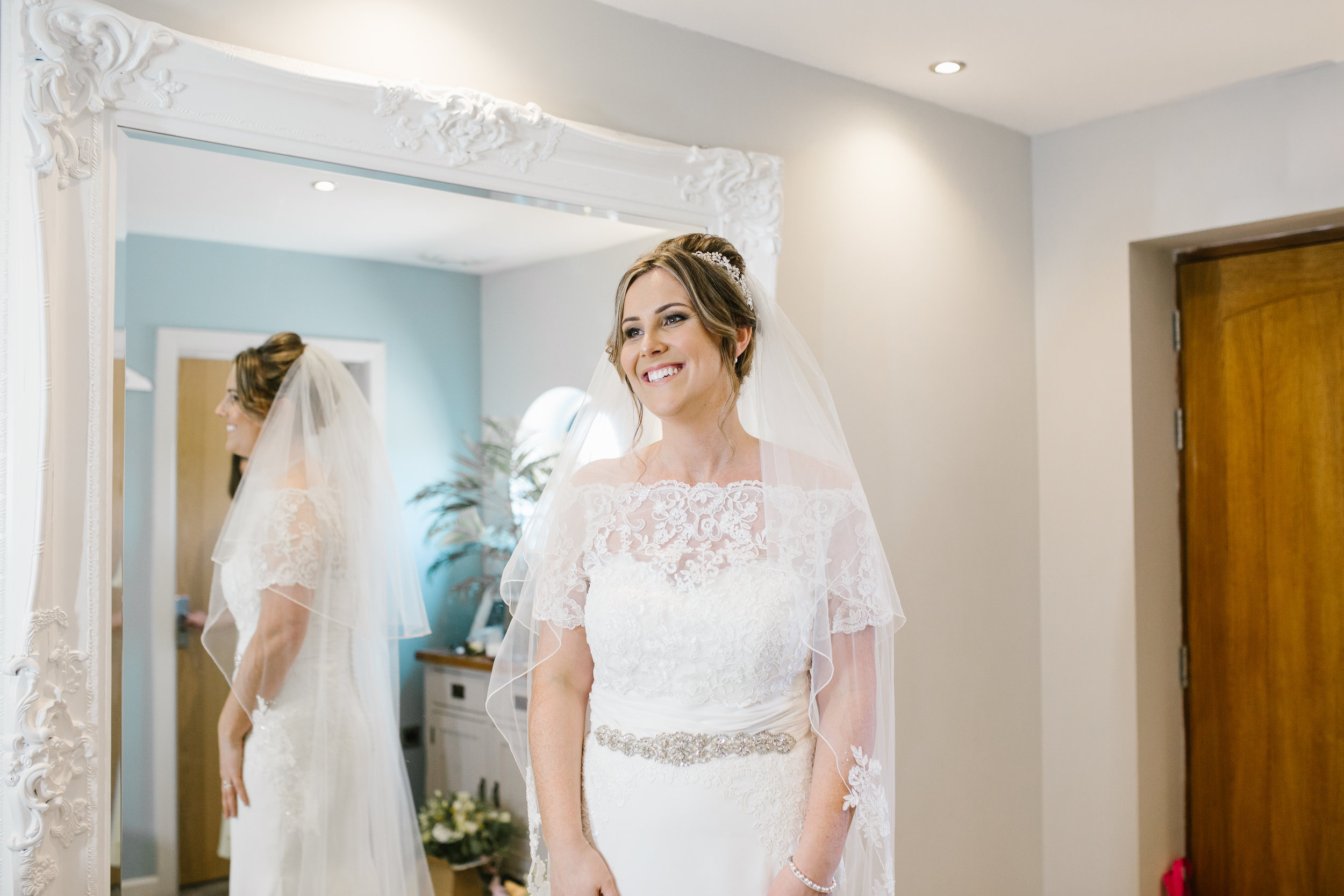 natural smiling photo of bride in her wedding dress just before she leaves to marry her groom 