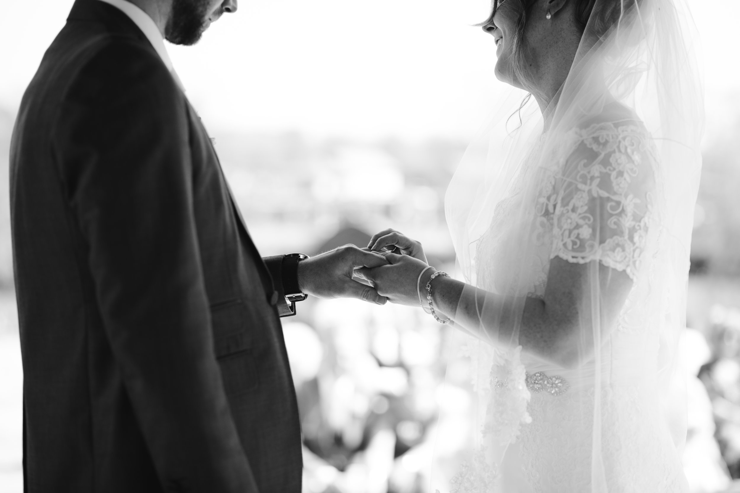 black and white detailed photo of the bride and groom exchanging rings 