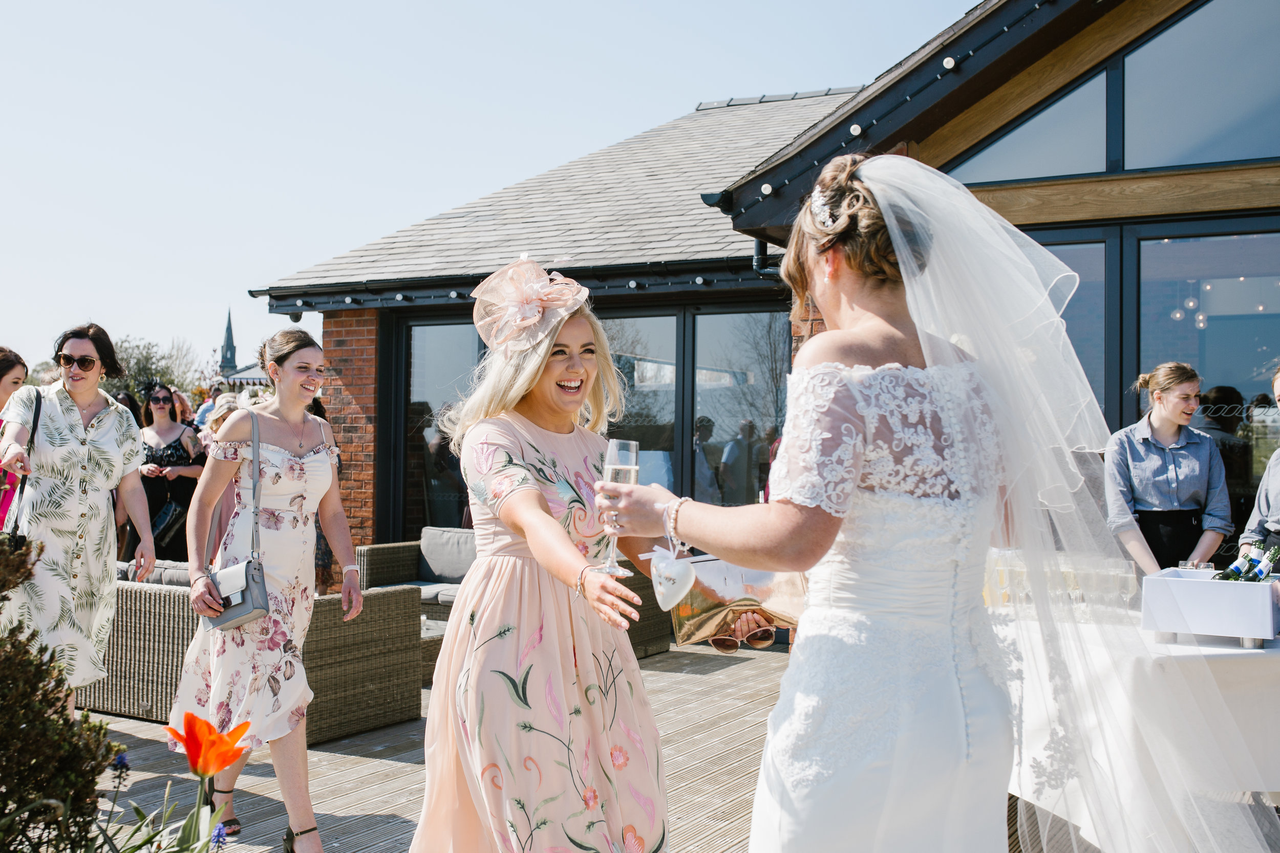 bride being greeted by her guests at her outdoor wedding in the boat house aston marina in staffordshire