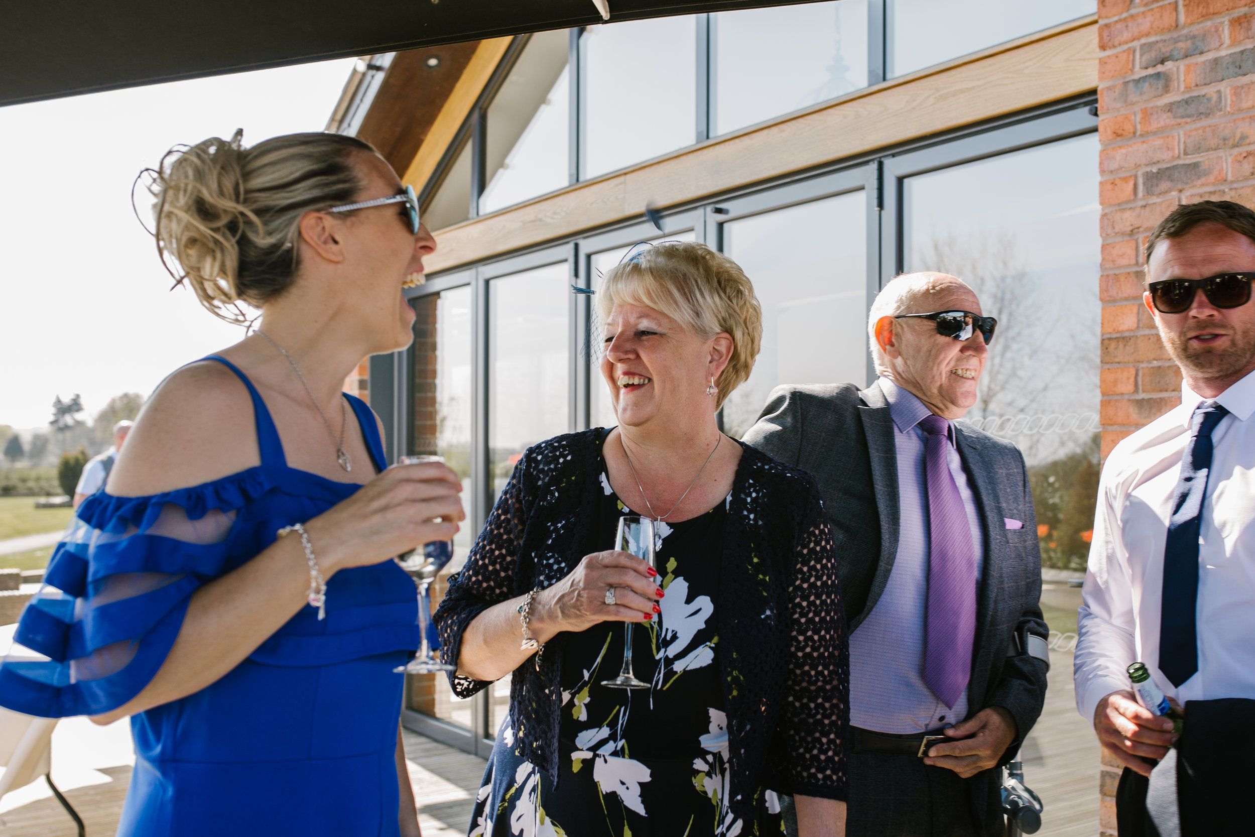 natural photograph of wedding guests laughing together at the boat house aston marina