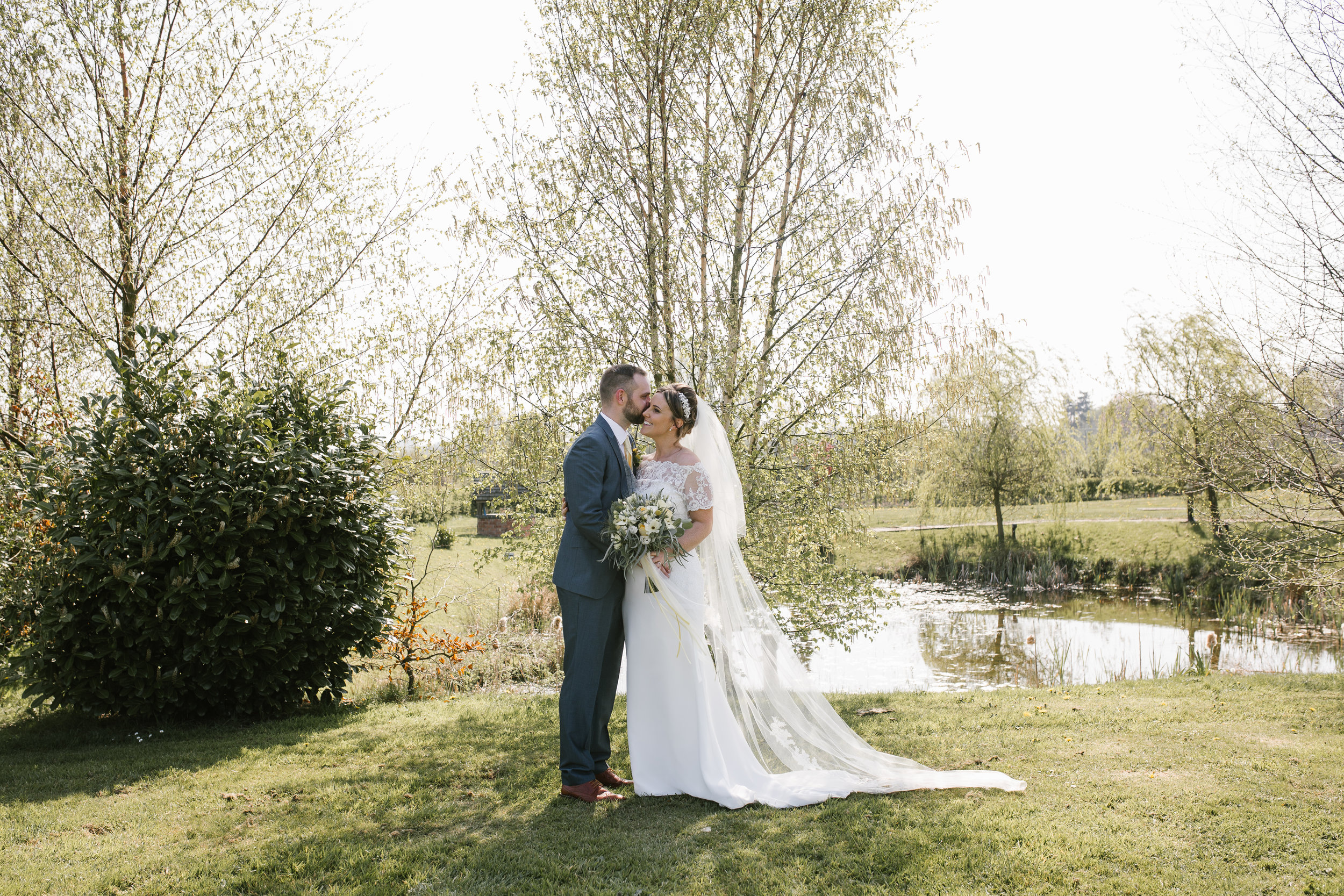 groom whispering into his brides ear at aston marina boat house wedding venue 