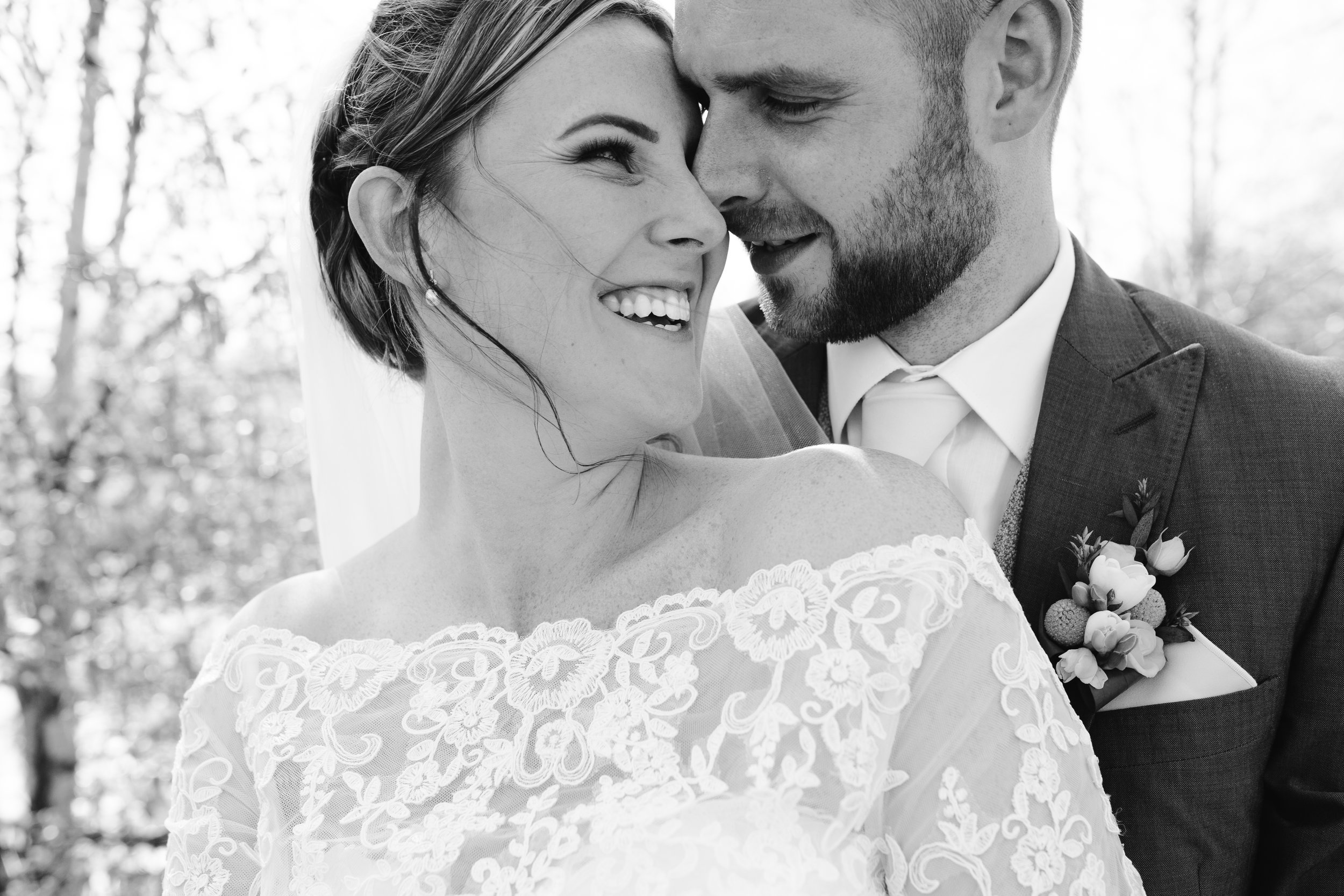 black and white photo of bride and groom snuggling together at their wedding in staffordshire