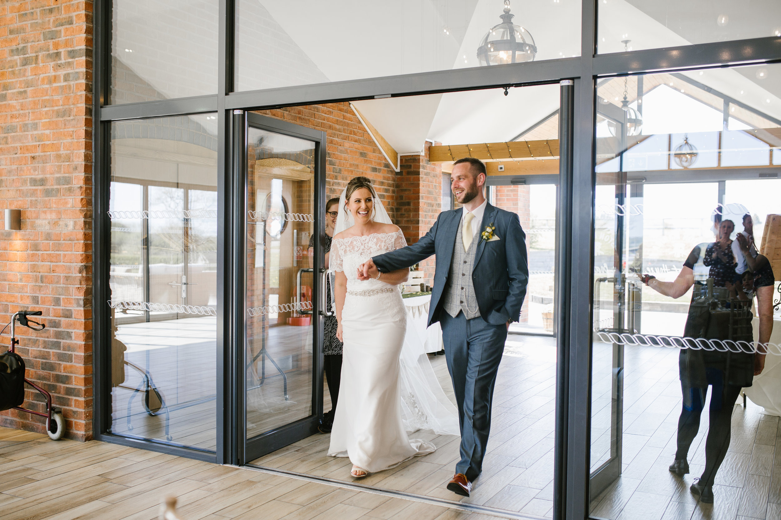 bride and groom make an entrance into the wedding breakfast and get cheered into the room by their guests