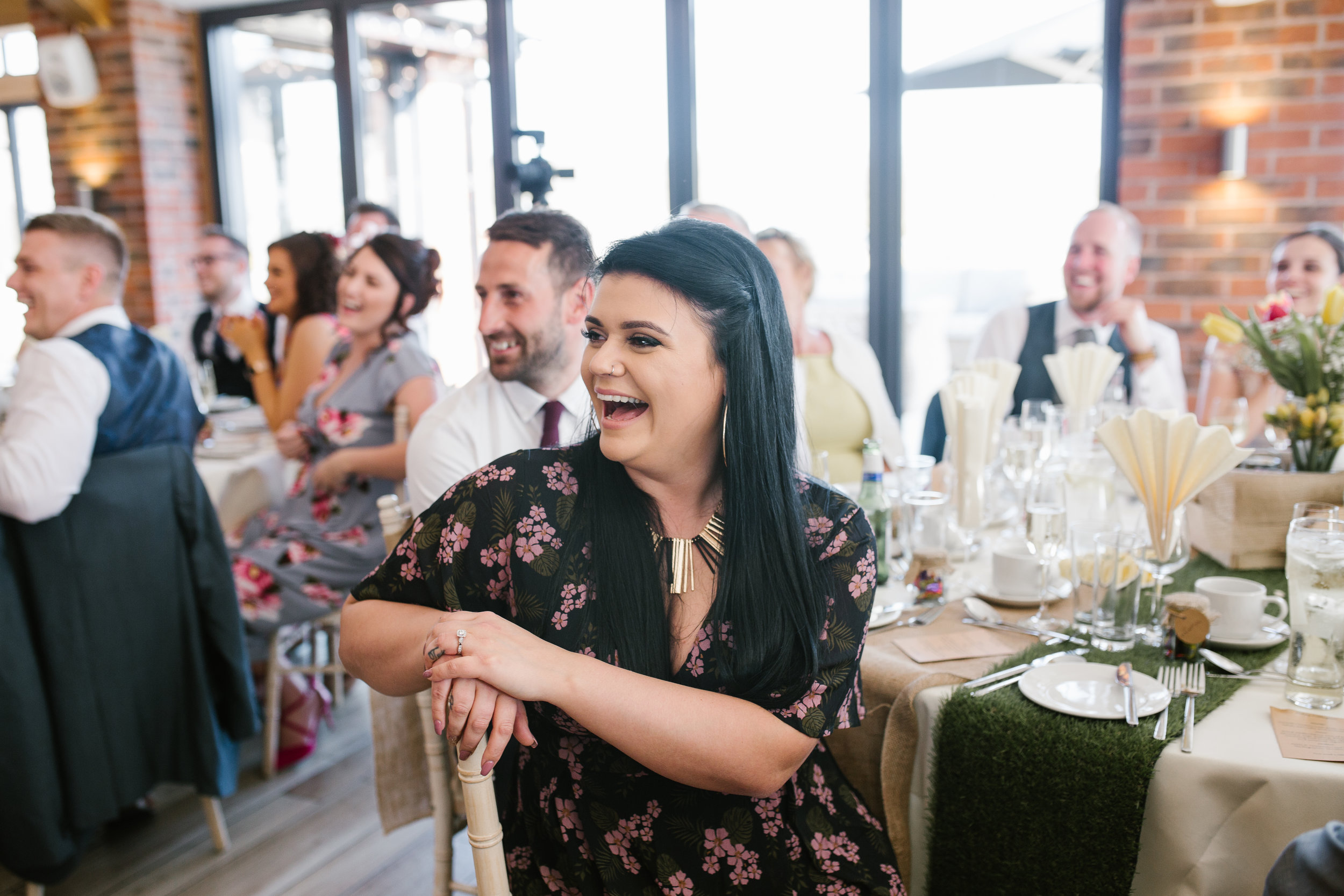 wedding guests laughing during father of the bride speech at the boat house wedding venue 