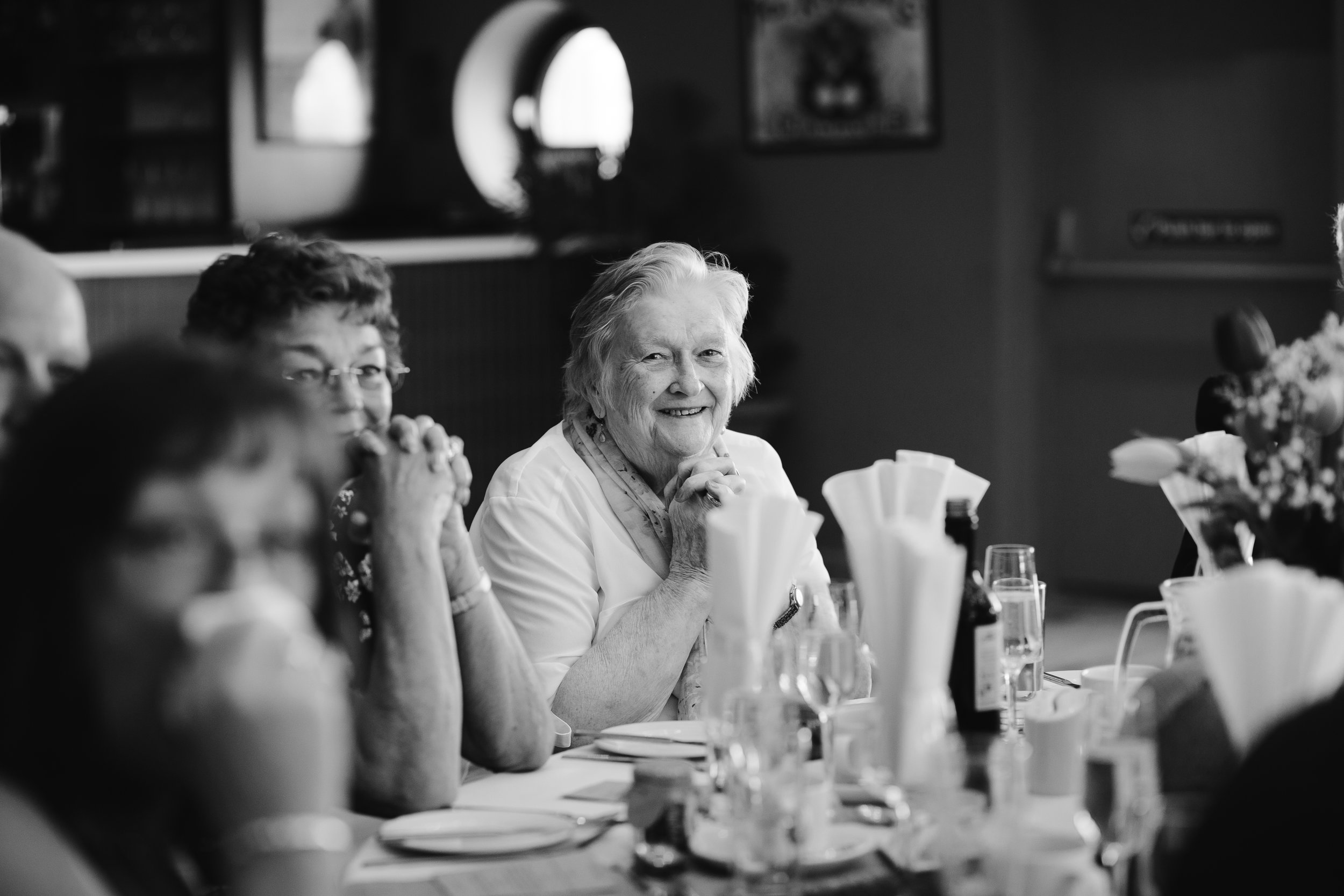 black and white photo of nan smiling during the wedding speeches 