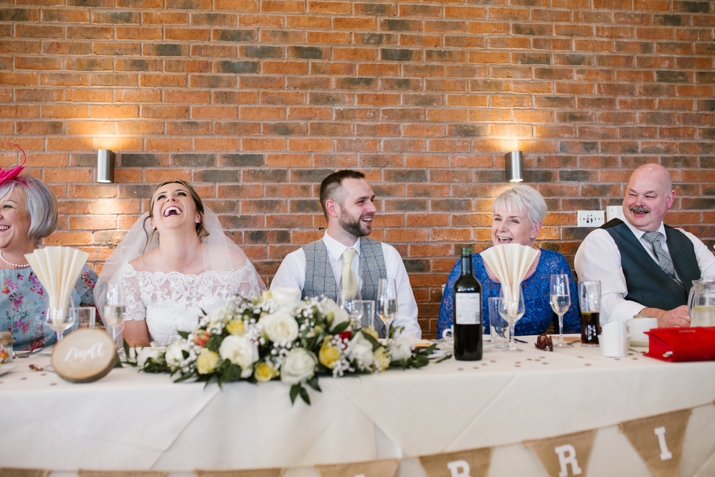 the top tabel laughing together during the wedding speeches