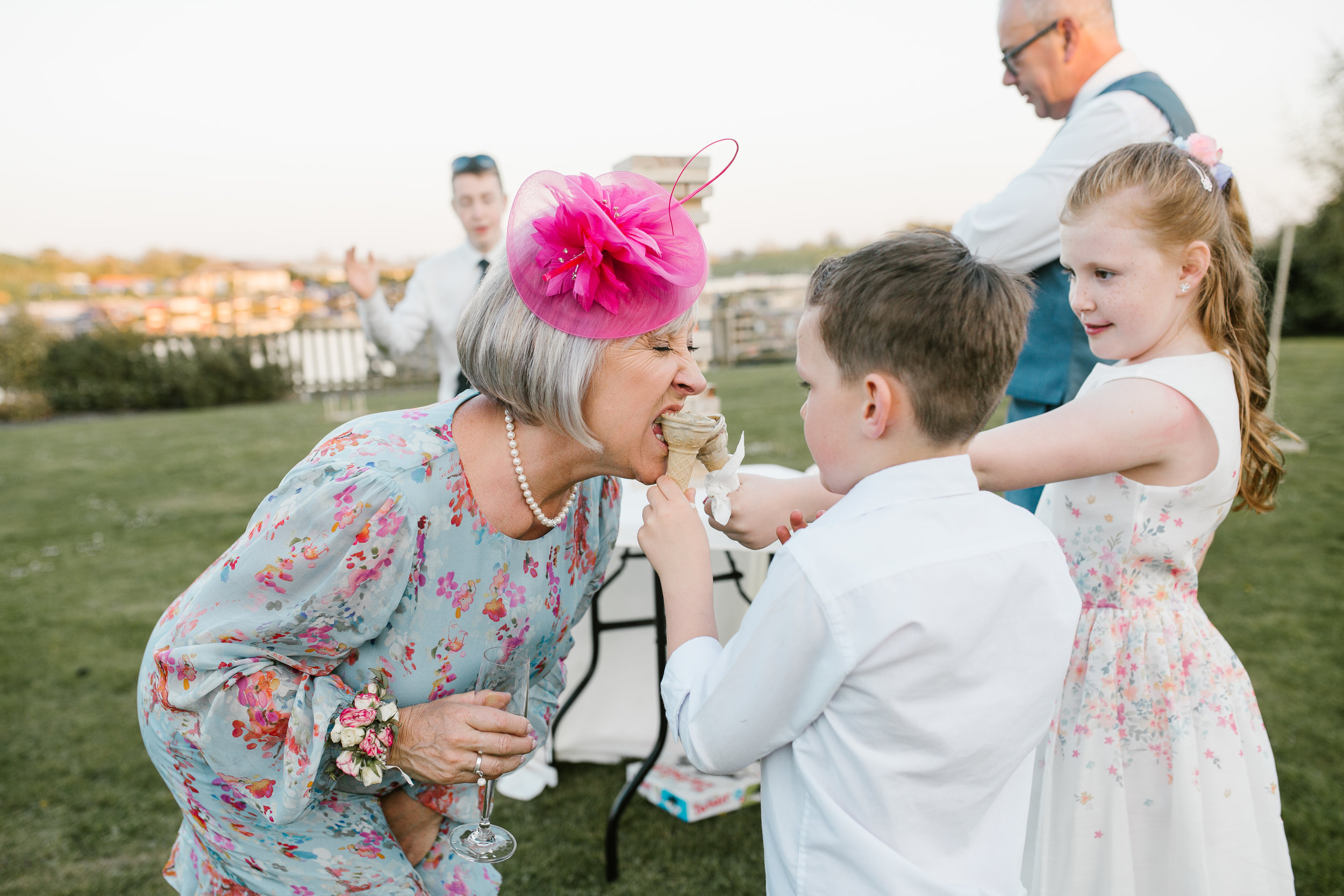 children at a wedding feed ice cream to the mother of the bride